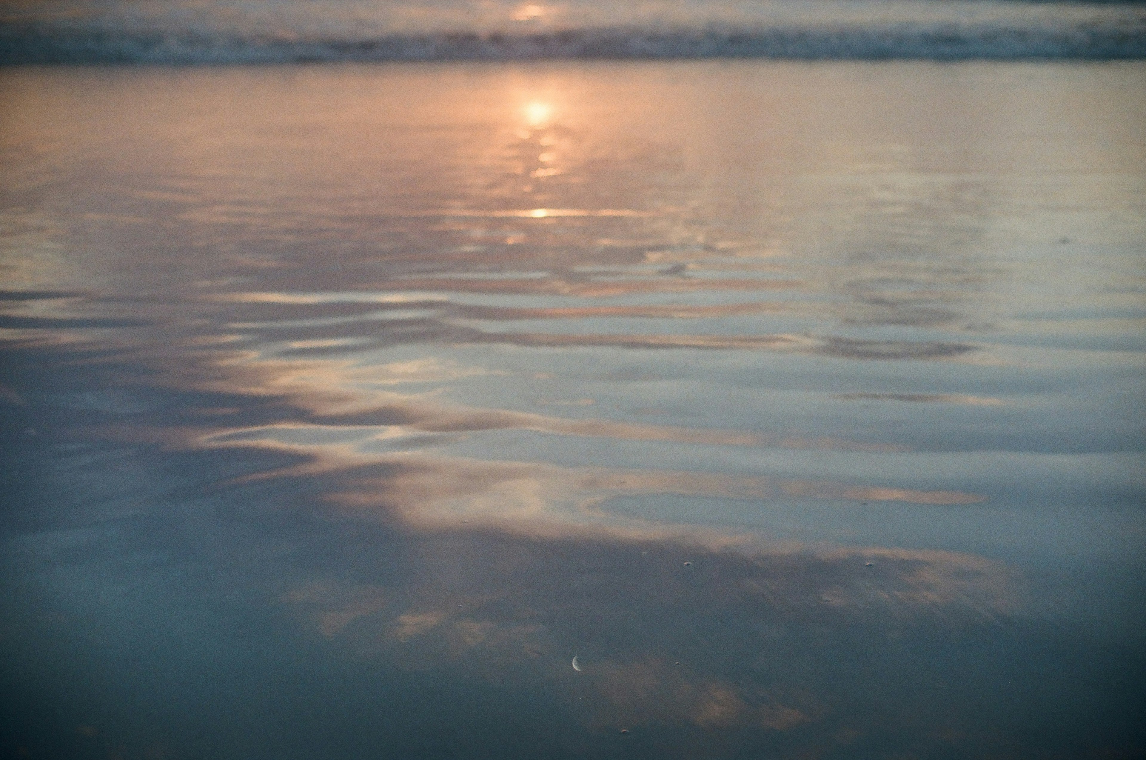 海の水面に反射する夕日の柔らかな光