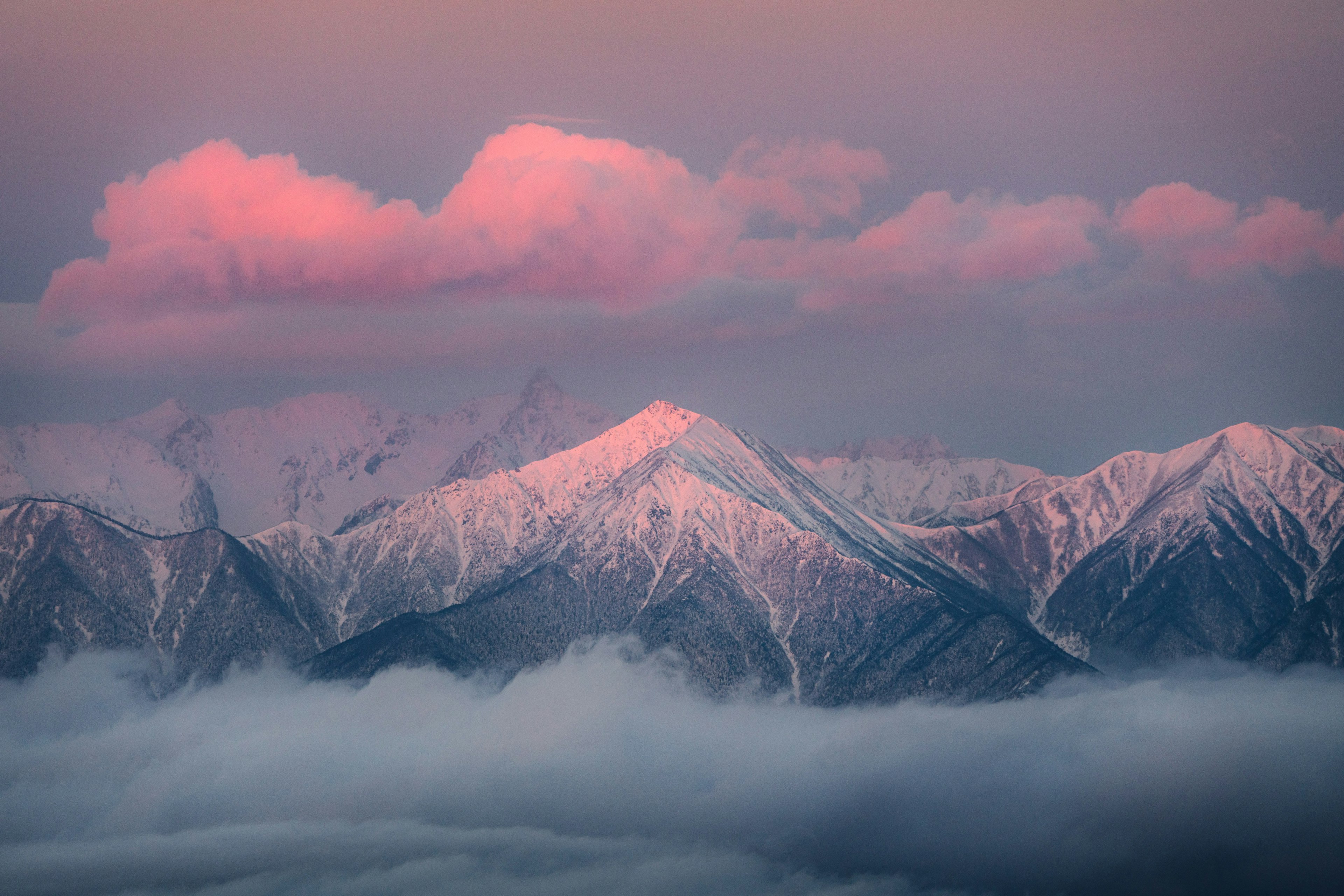 Beeindruckende Landschaft mit schneebedeckten Bergen und rosa Wolken