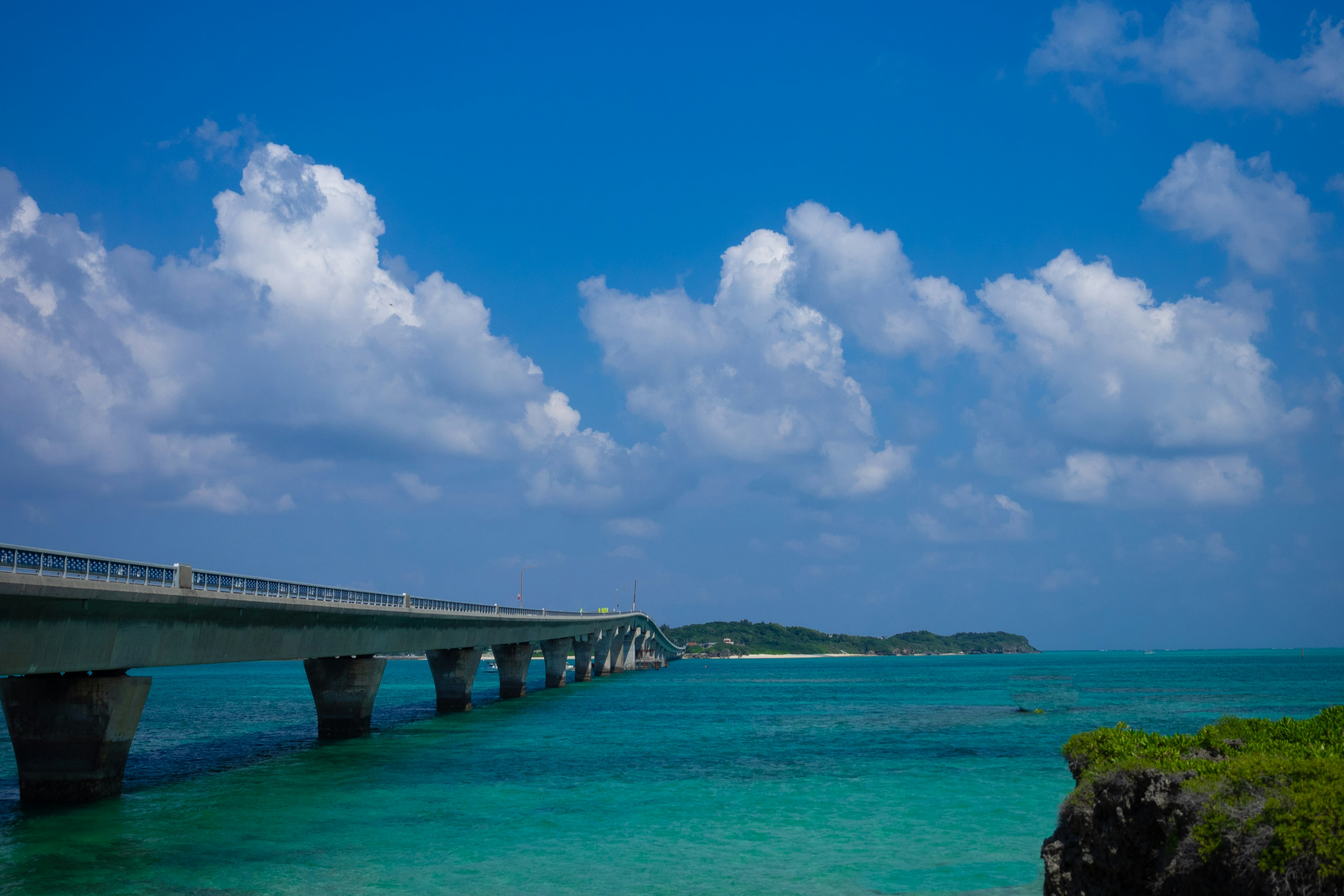 ทิวทัศน์สะพานเหนือทะเลสีฟ้าใต้ท้องฟ้าสีฟ้า