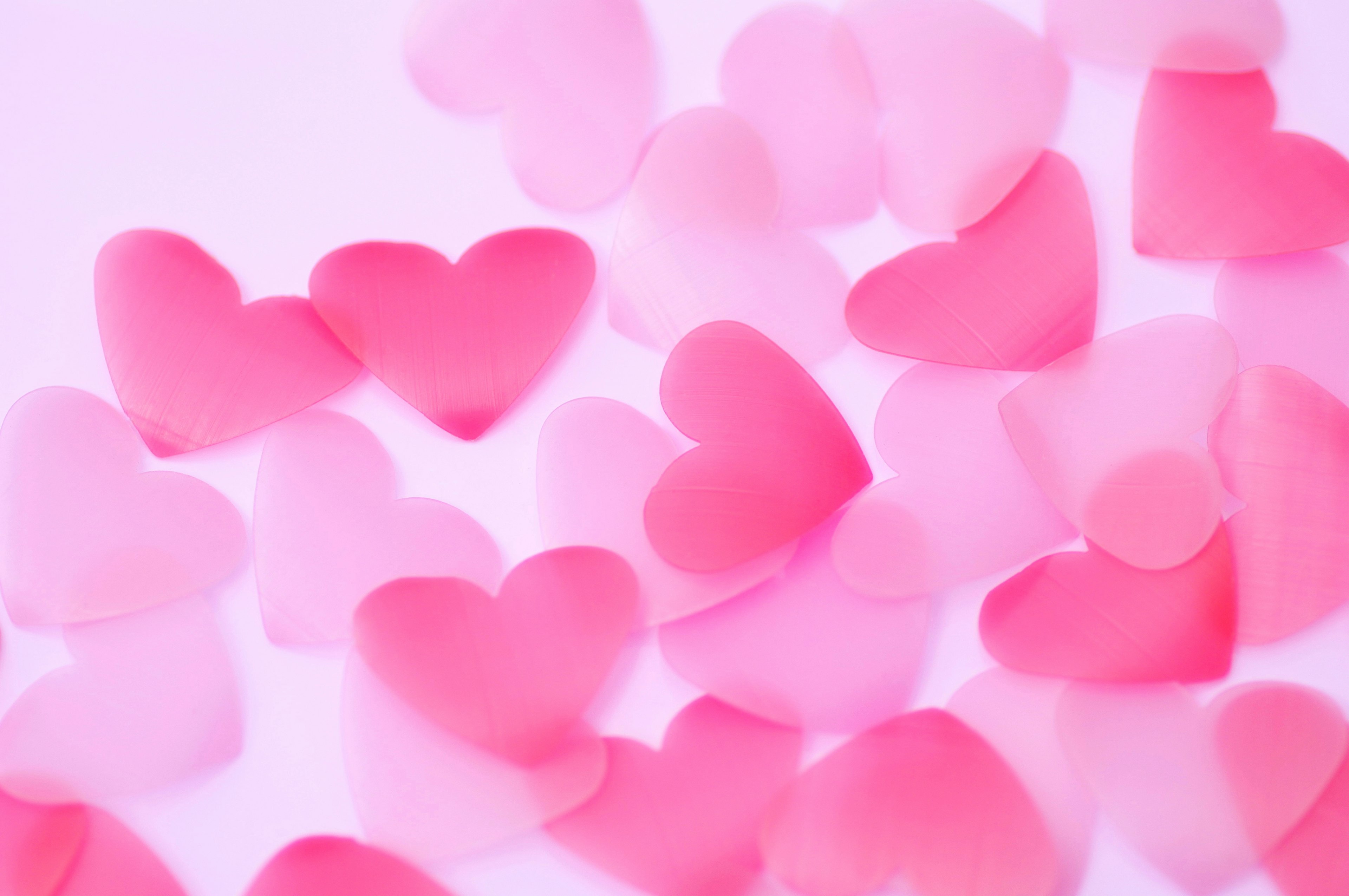 Scattered pink heart-shaped decorations on a light background