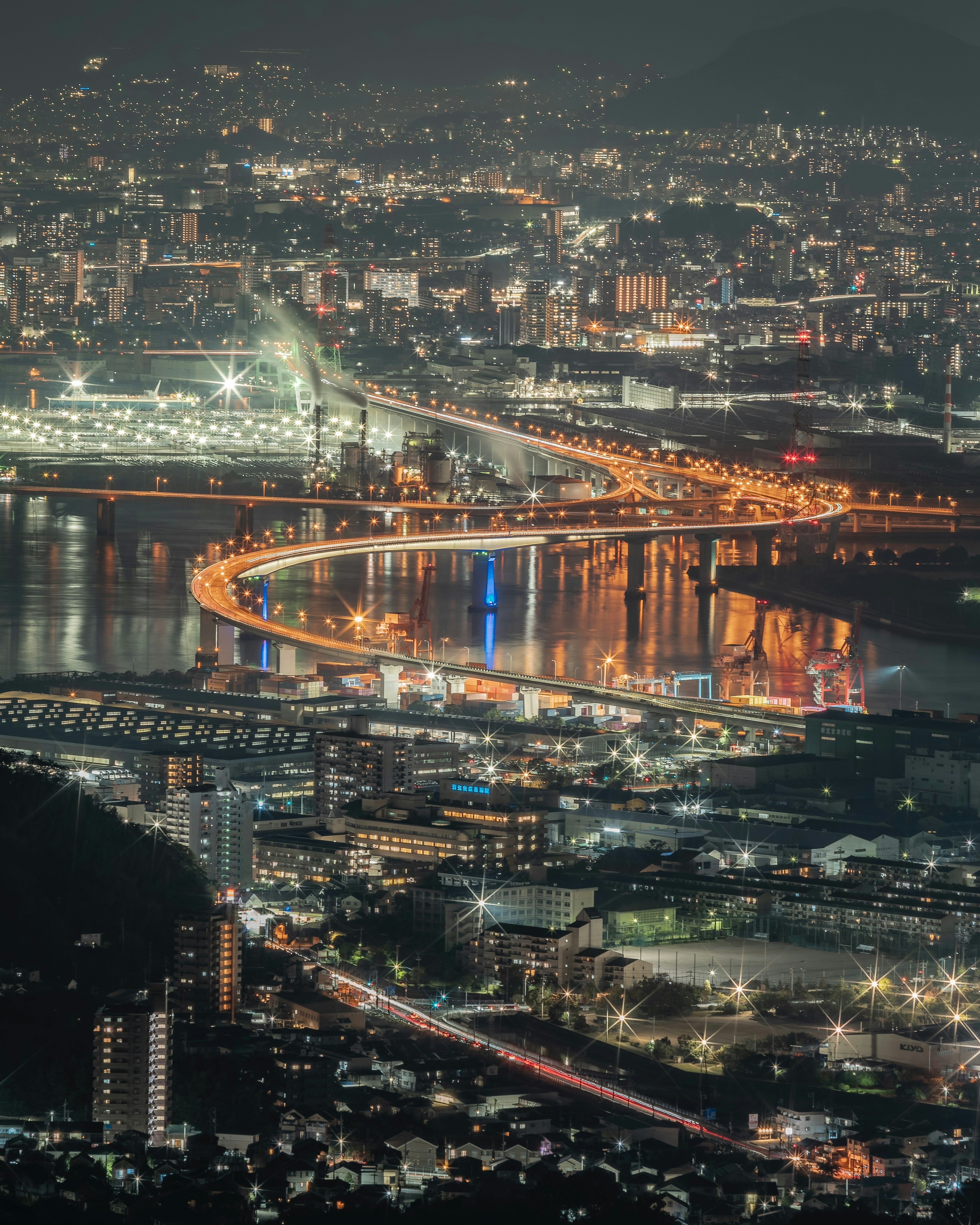 Belle vue nocturne de la ville avec des lumières et un pont sinueux