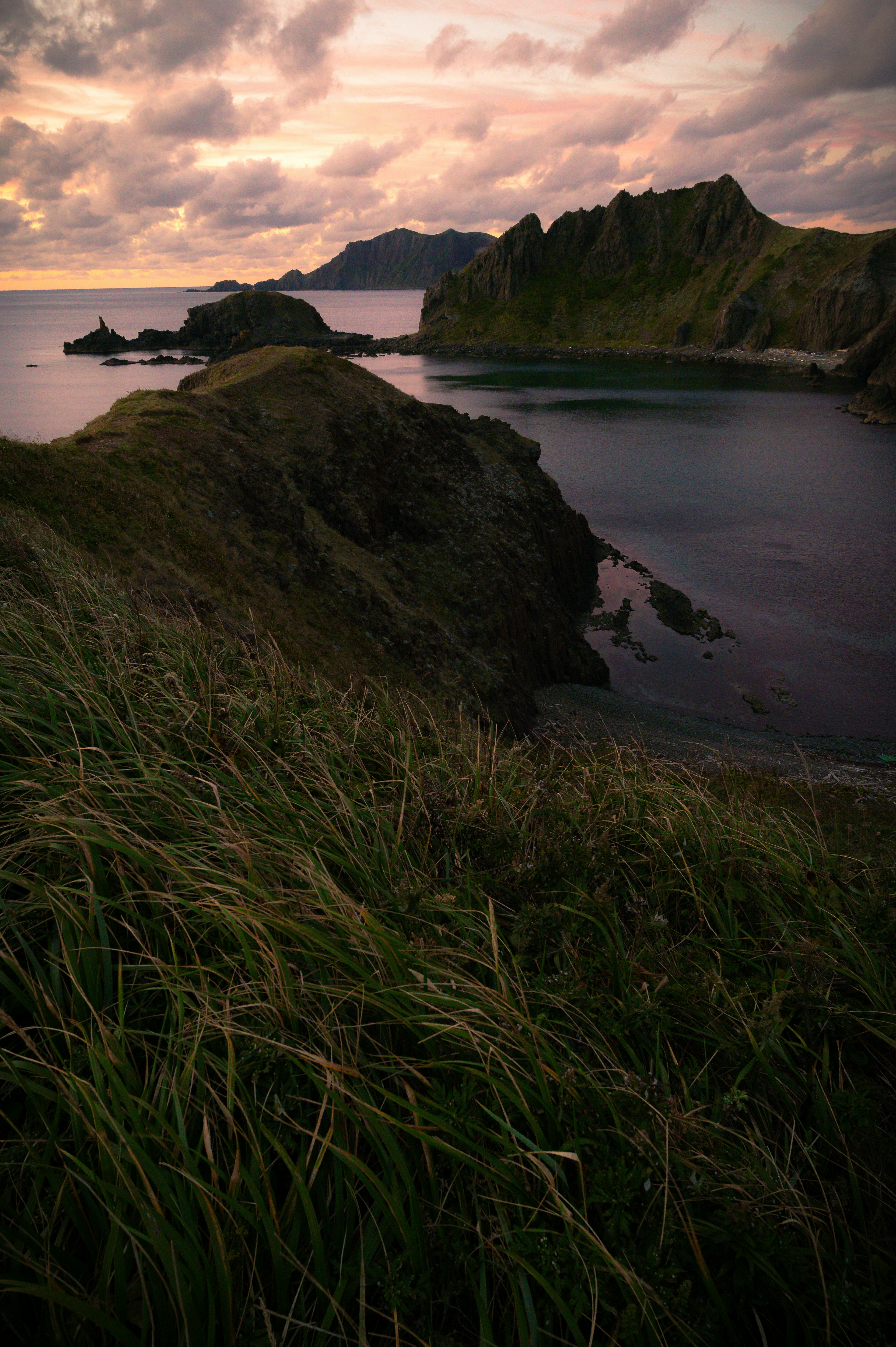 Scenic coastline and rocky landscape viewed from a grassy hill