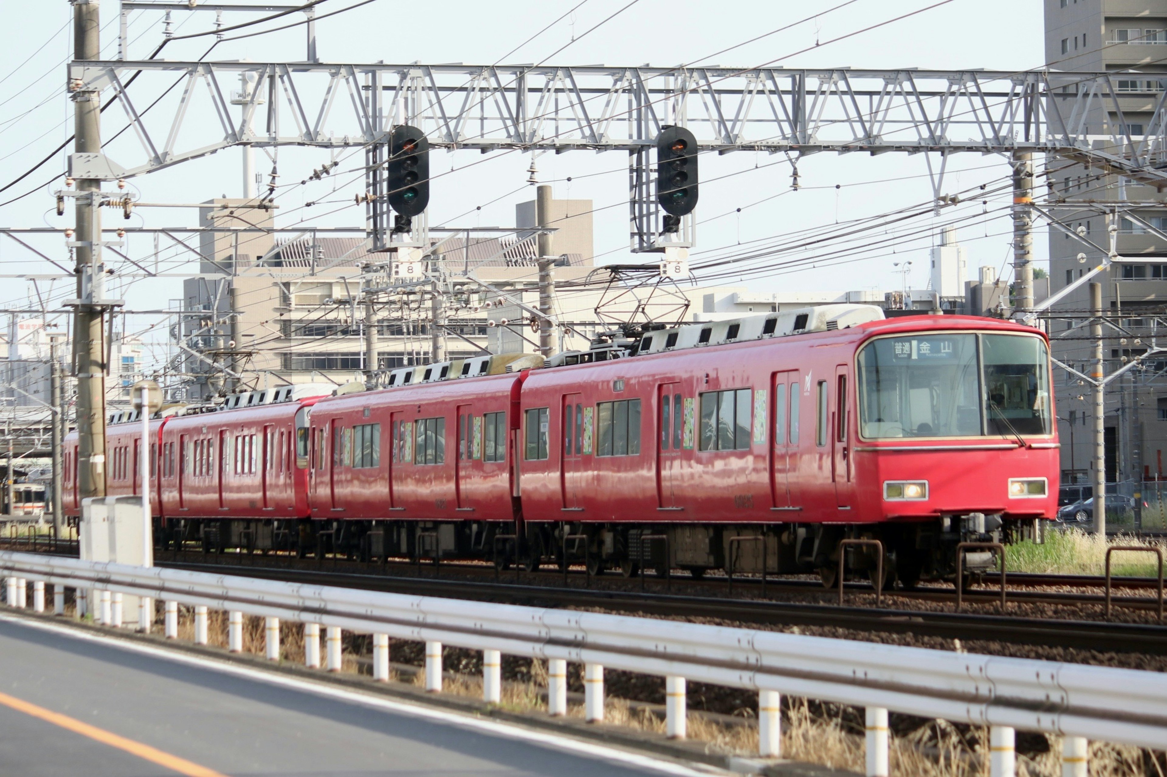 Treno rosso sui binari con sfondo urbano