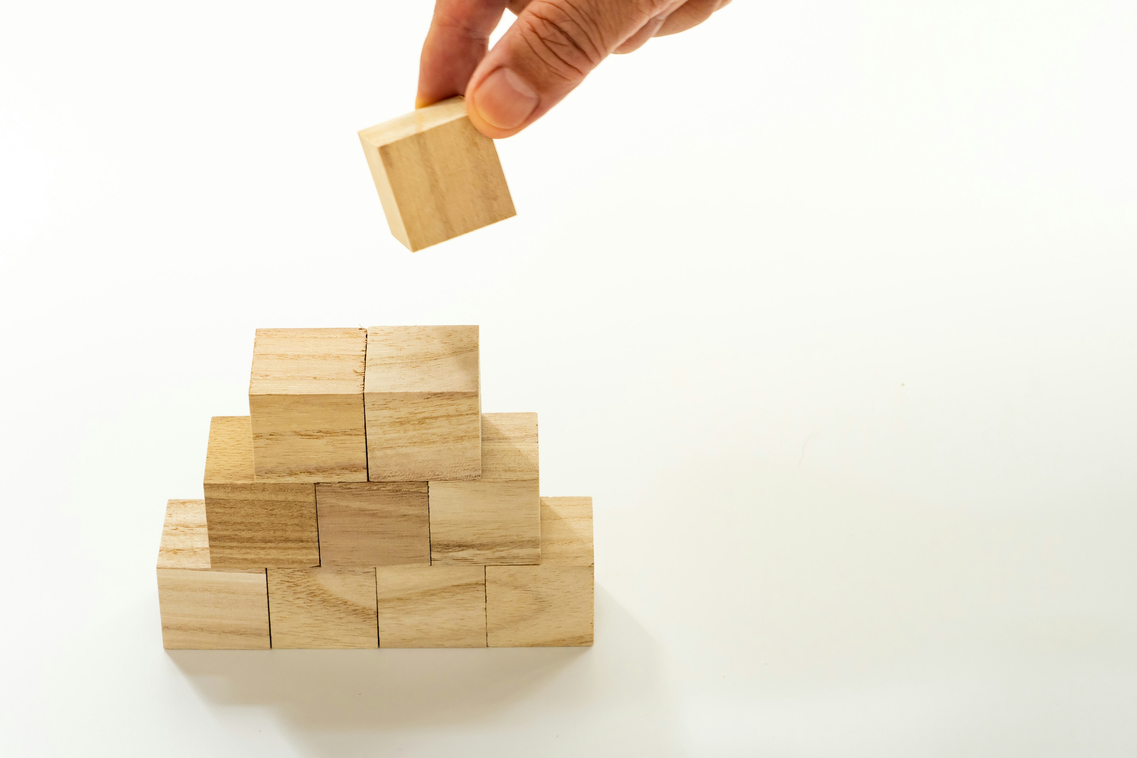 Image of a hand stacking wooden blocks