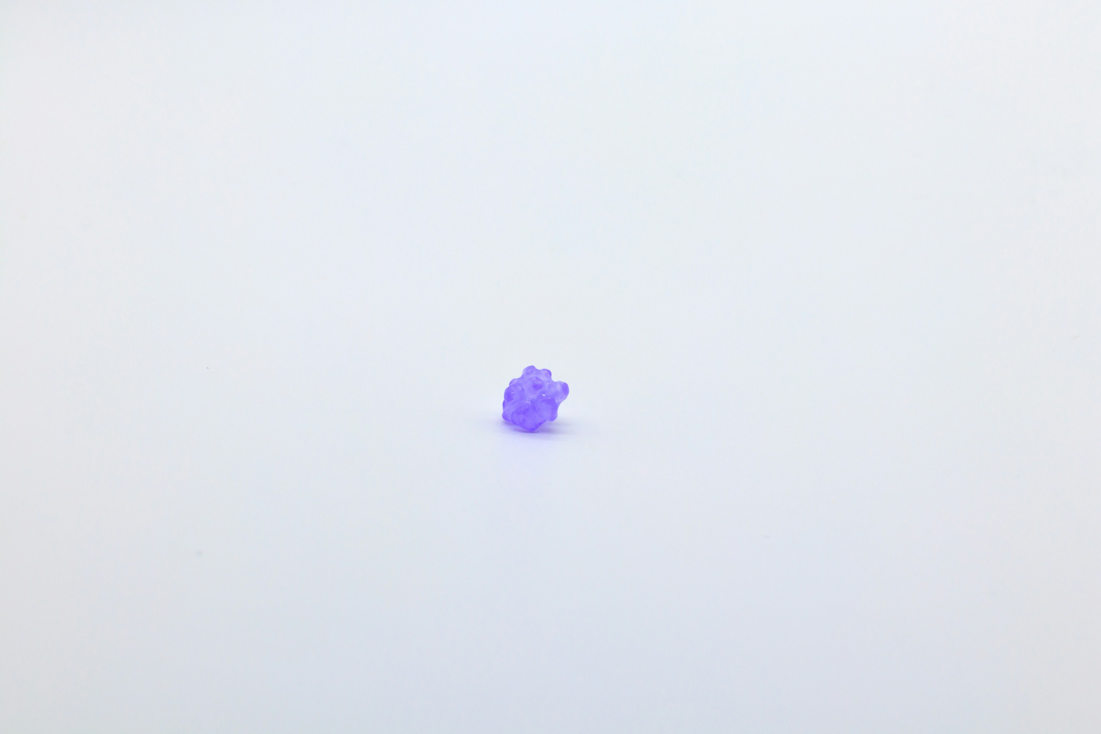 Petit cristal violet sur un fond blanc