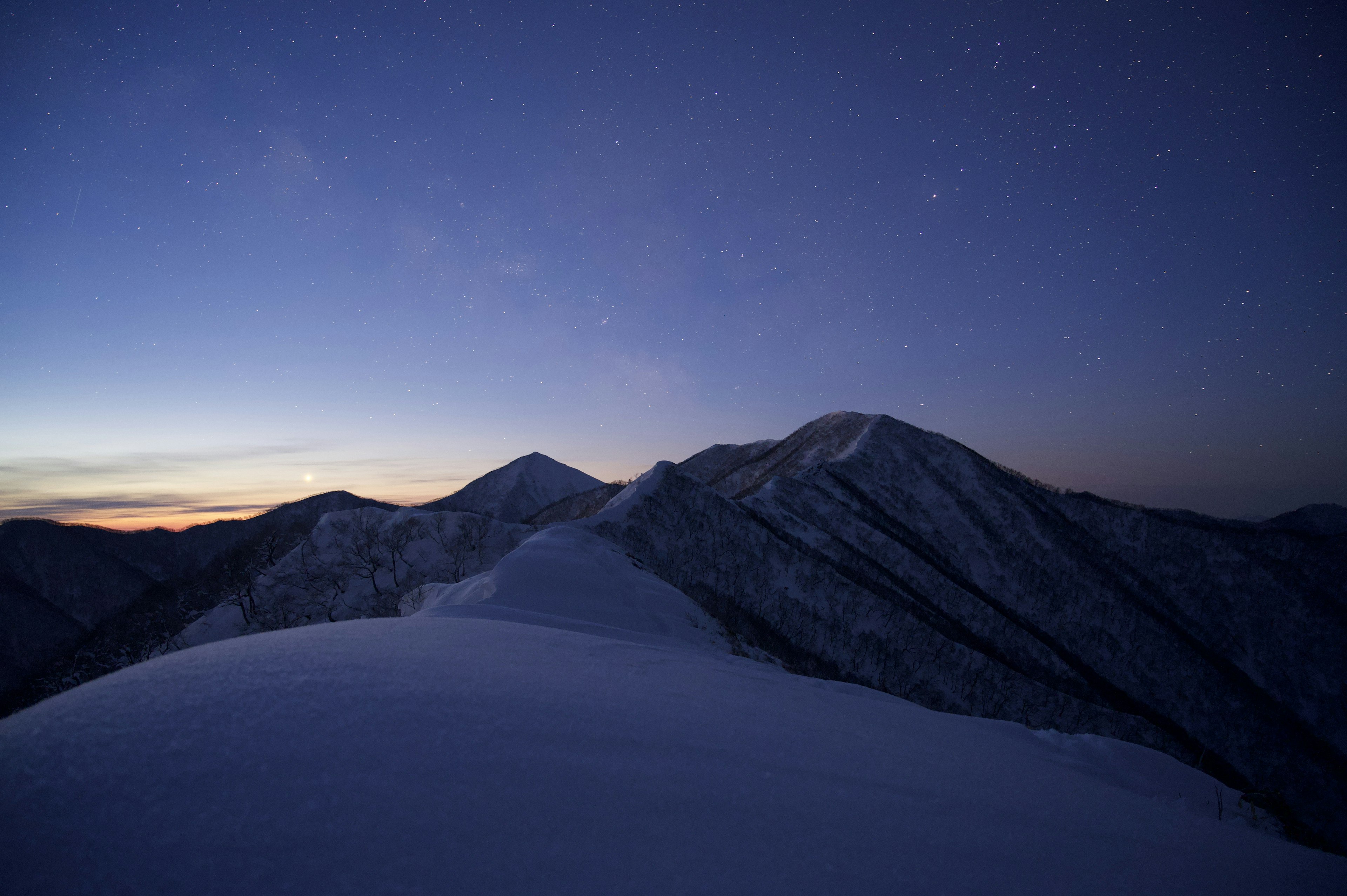 雪に覆われた山々の夜景が広がる