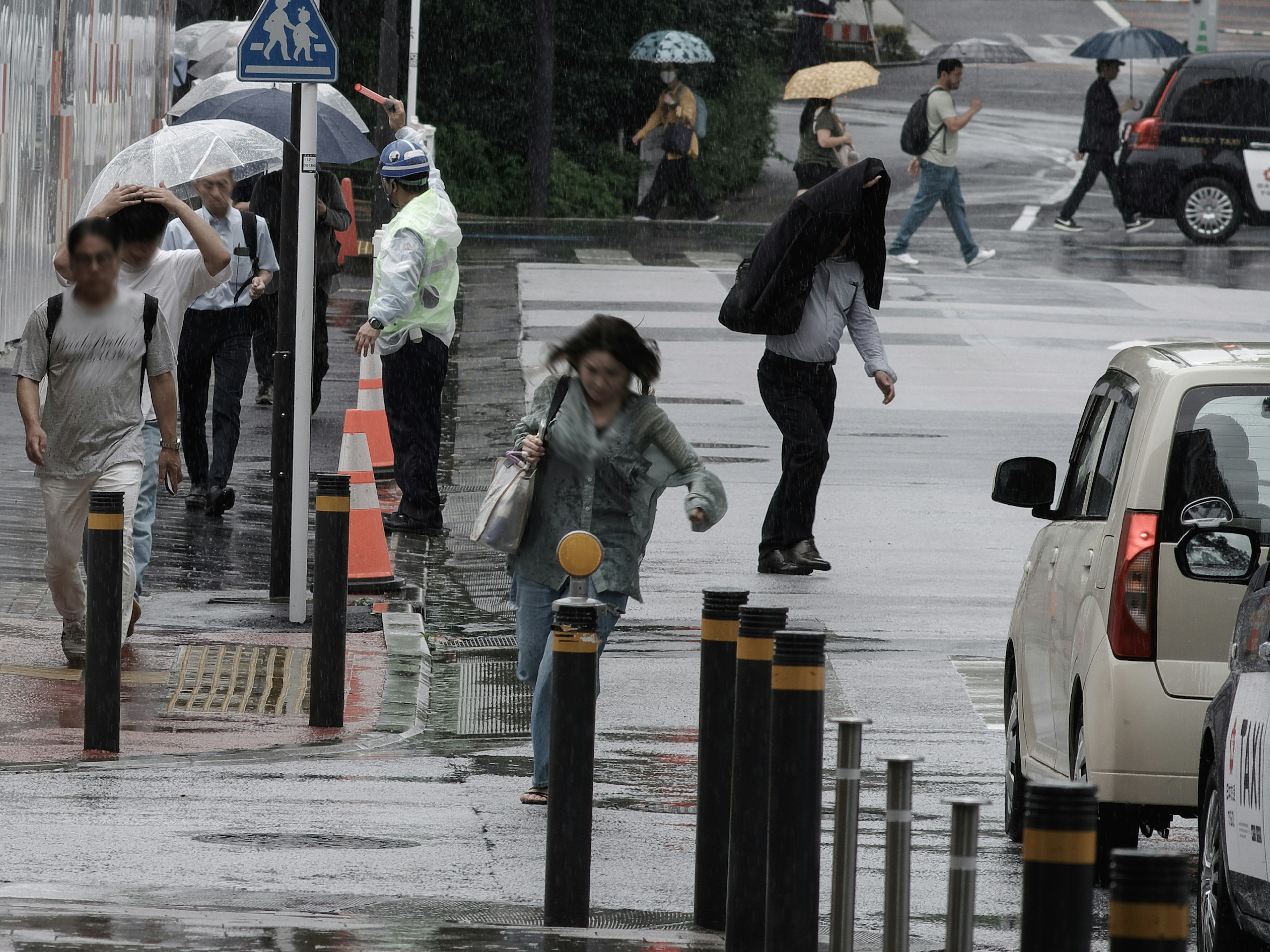 Personas caminando bajo la lluvia con paraguas en un entorno urbano