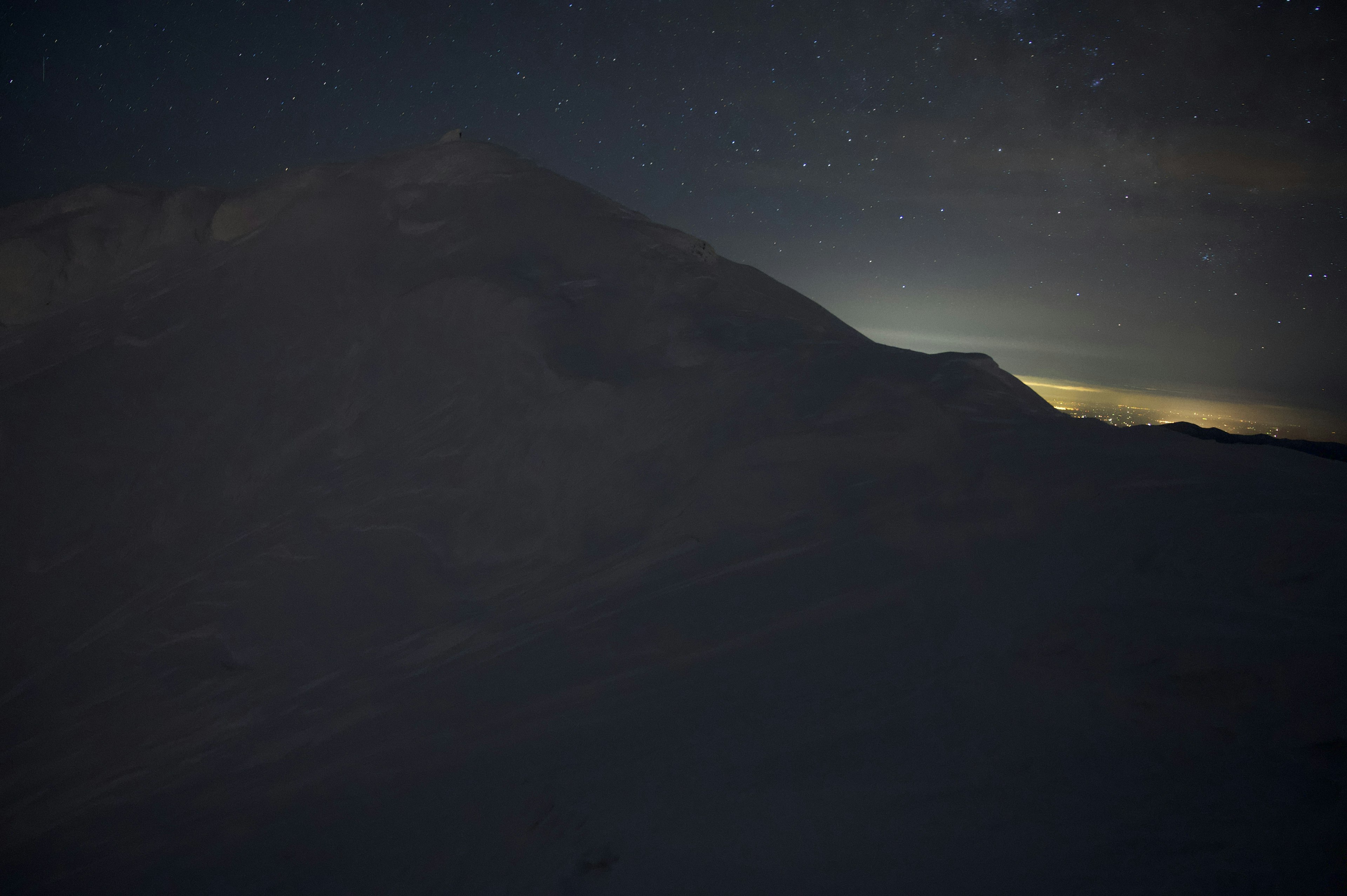 Dark silhouette of a mountain with a starry sky