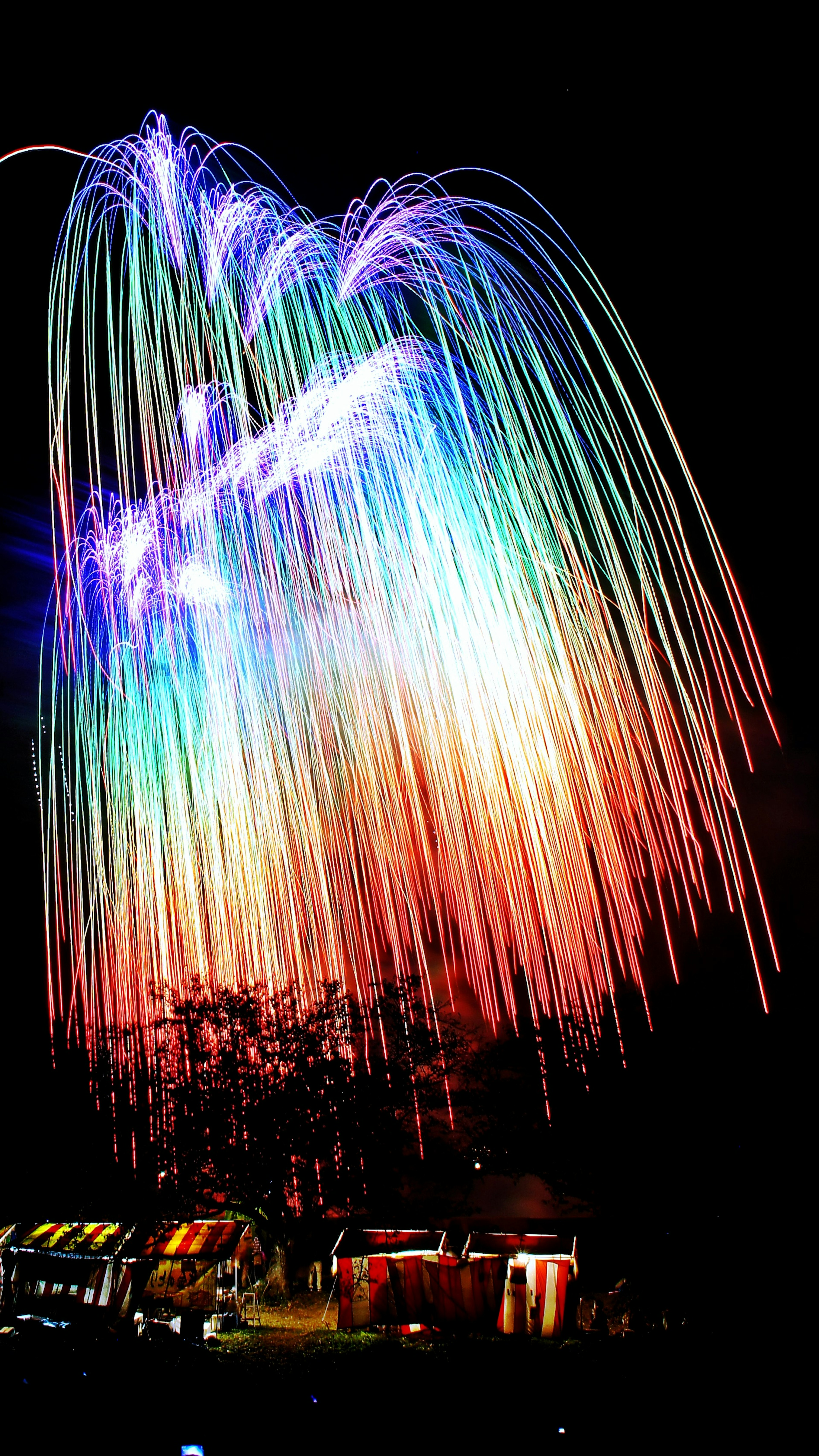 Des feux d'artifice colorés tombant dans le ciel nocturne