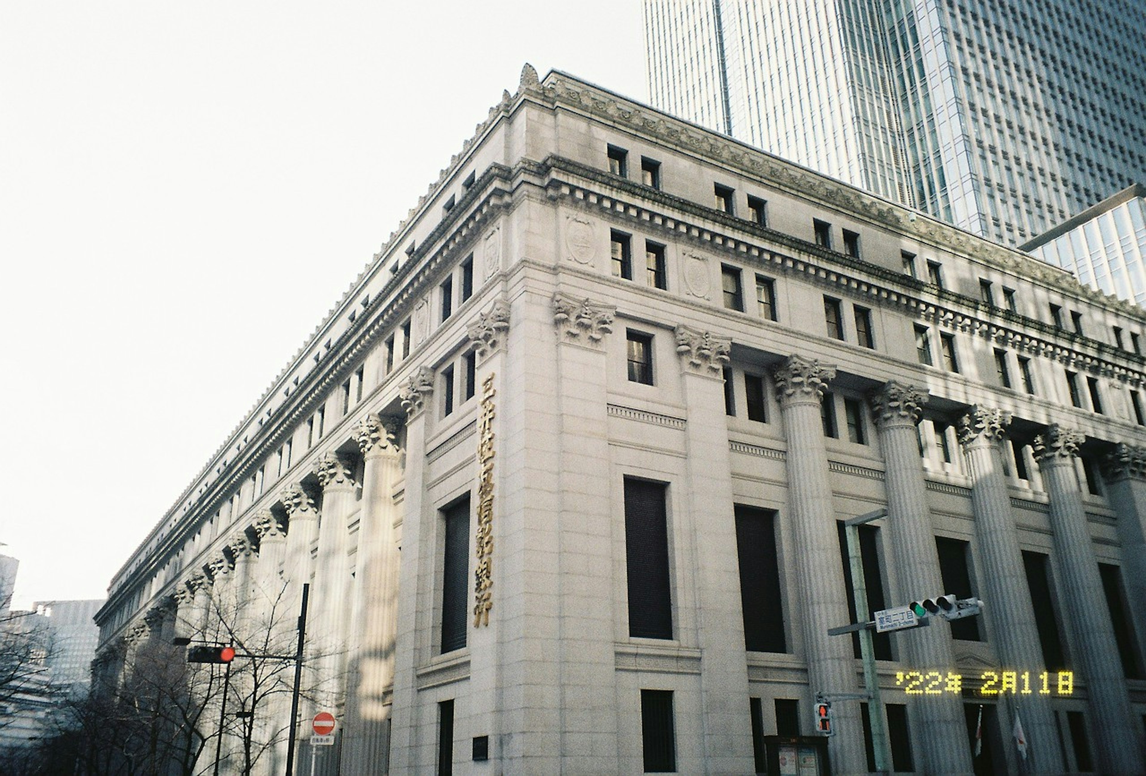 Corner view of a classical building with modern skyscrapers in the background