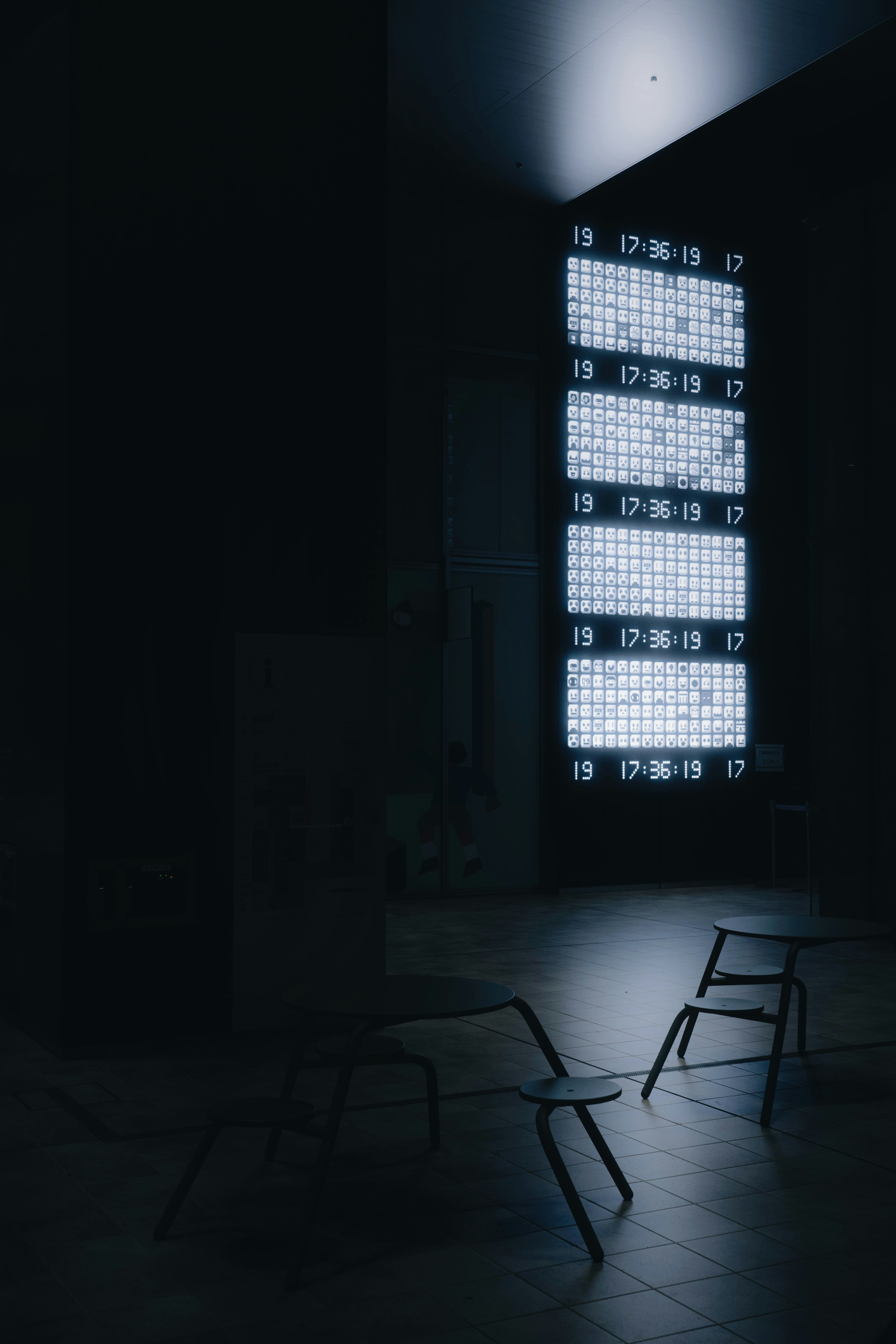 Chaises métalliques dans une pièce sombre éclairée par des fenêtres lumineuses