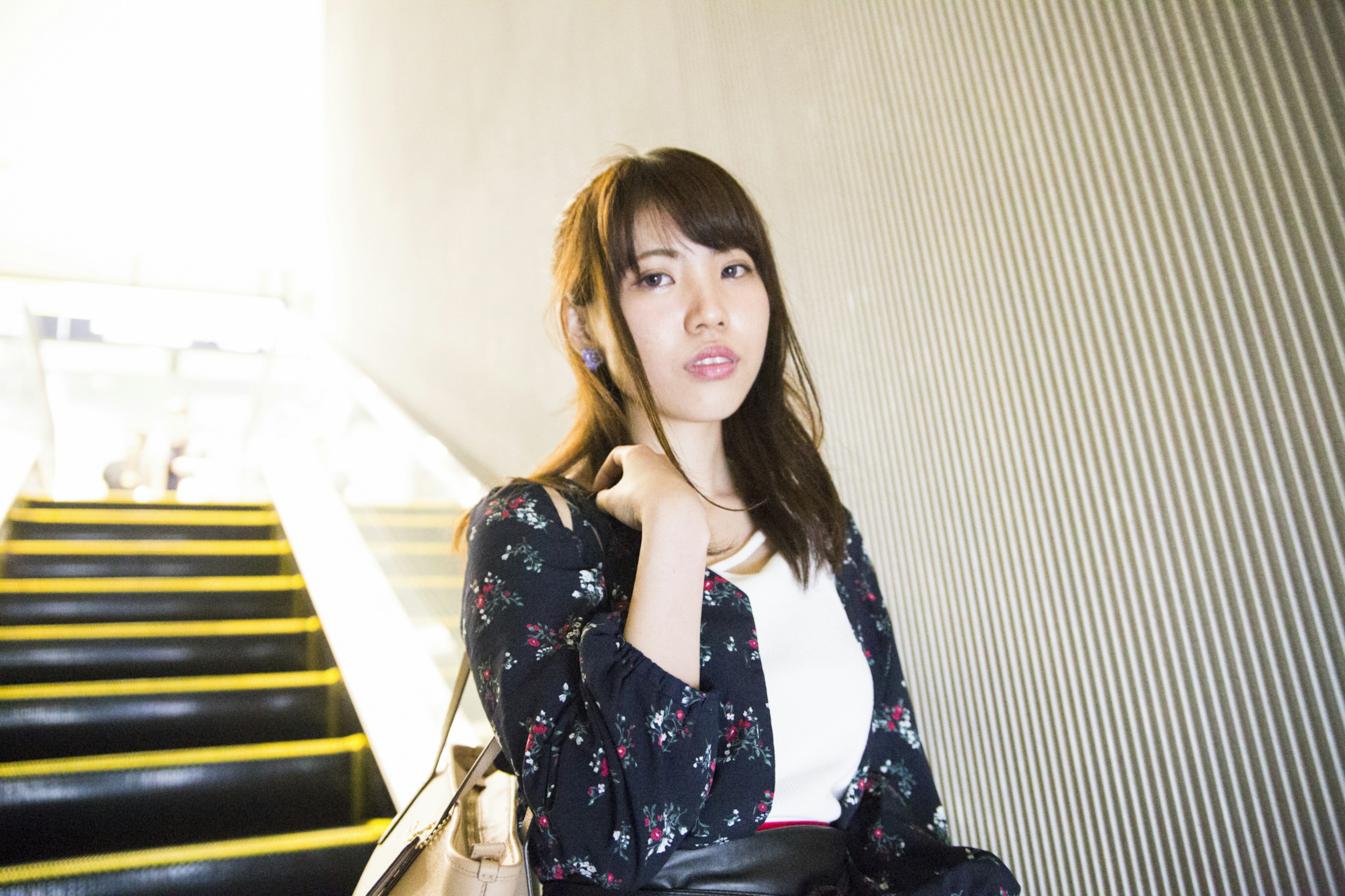 Portrait of a woman ascending stairs wearing floral clothing