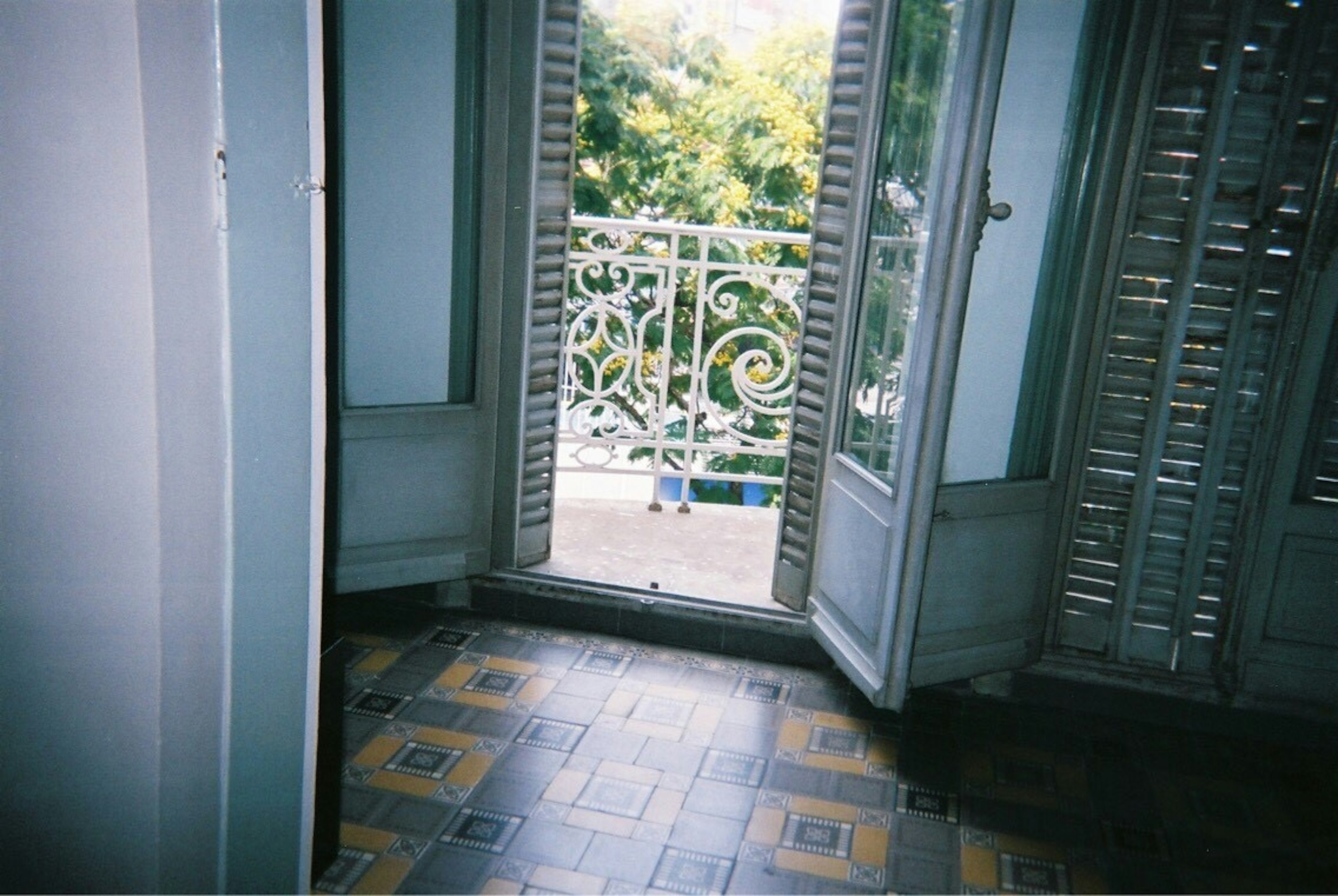 View from inside a room looking at a balcony with decorative railing