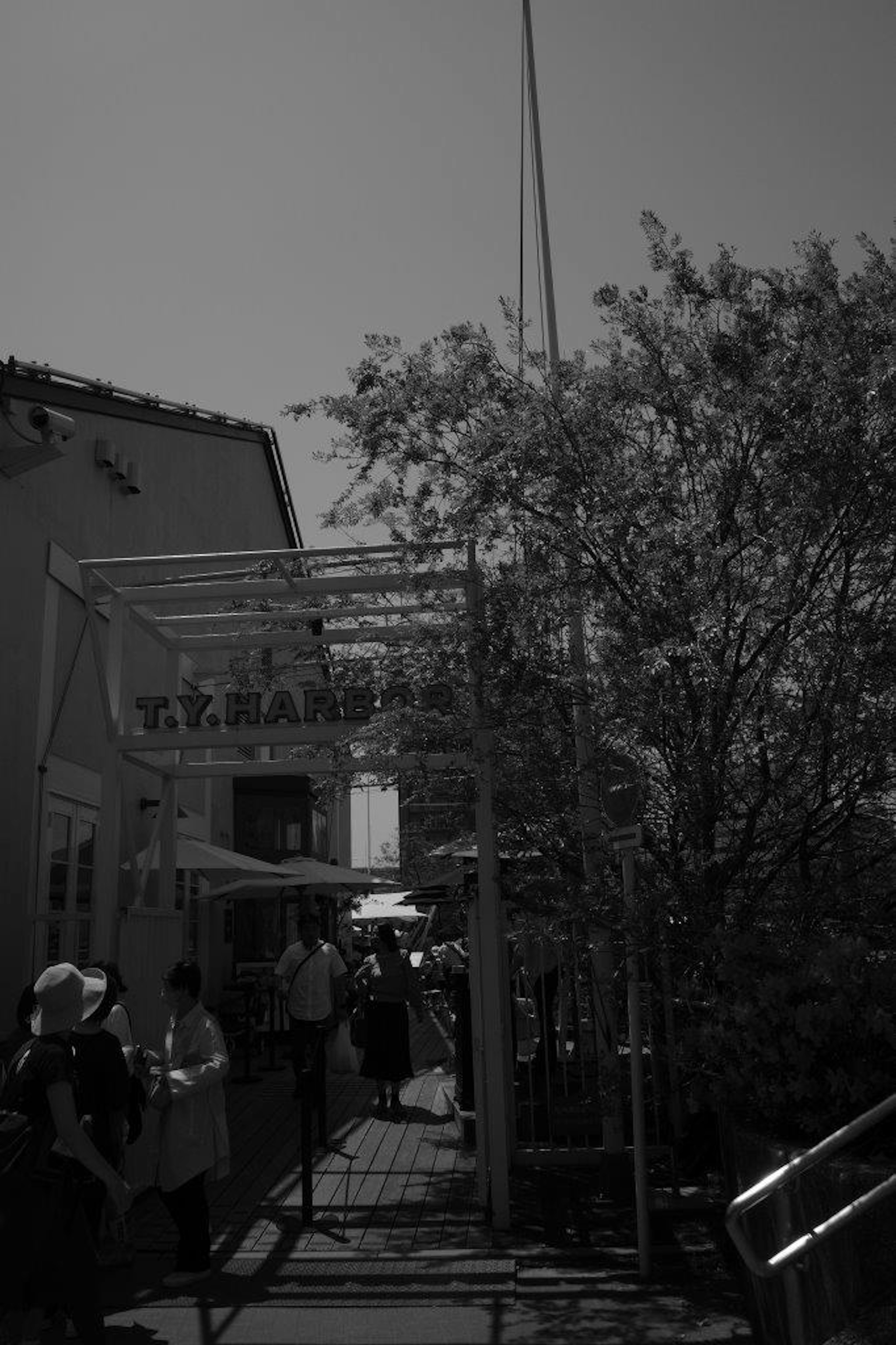 Black and white image showing the entrance of a restaurant with people