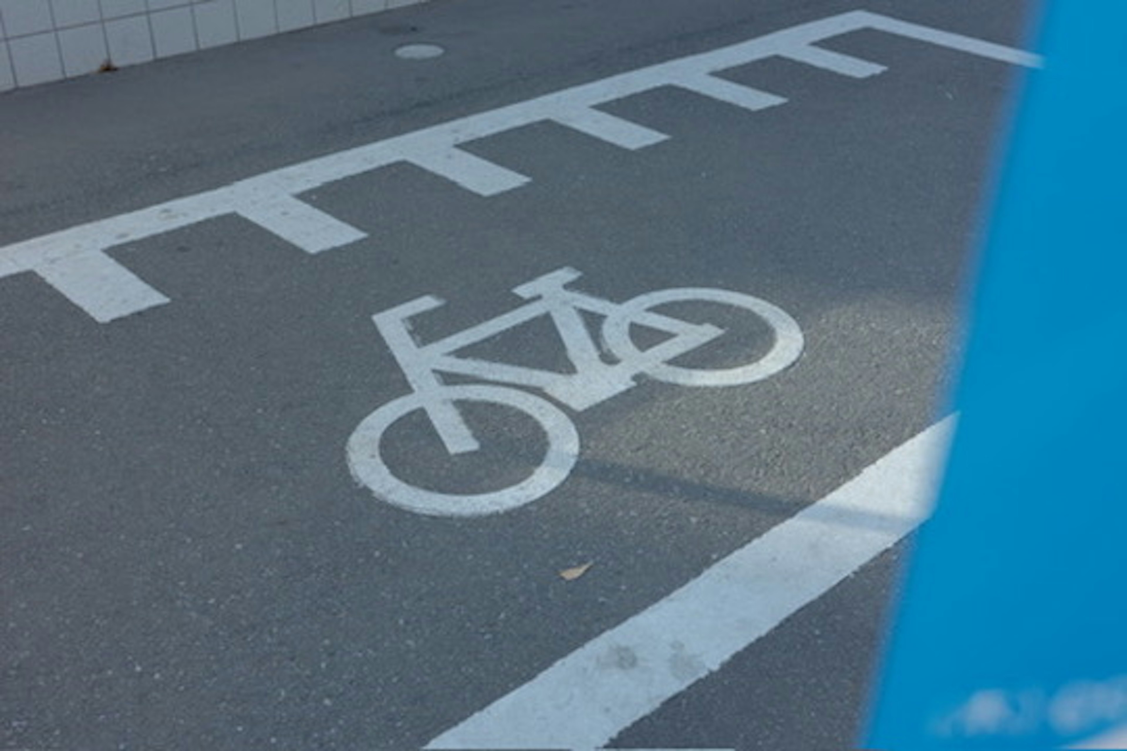 Segnaletica di corsia ciclabile sulla strada con sfondo blu