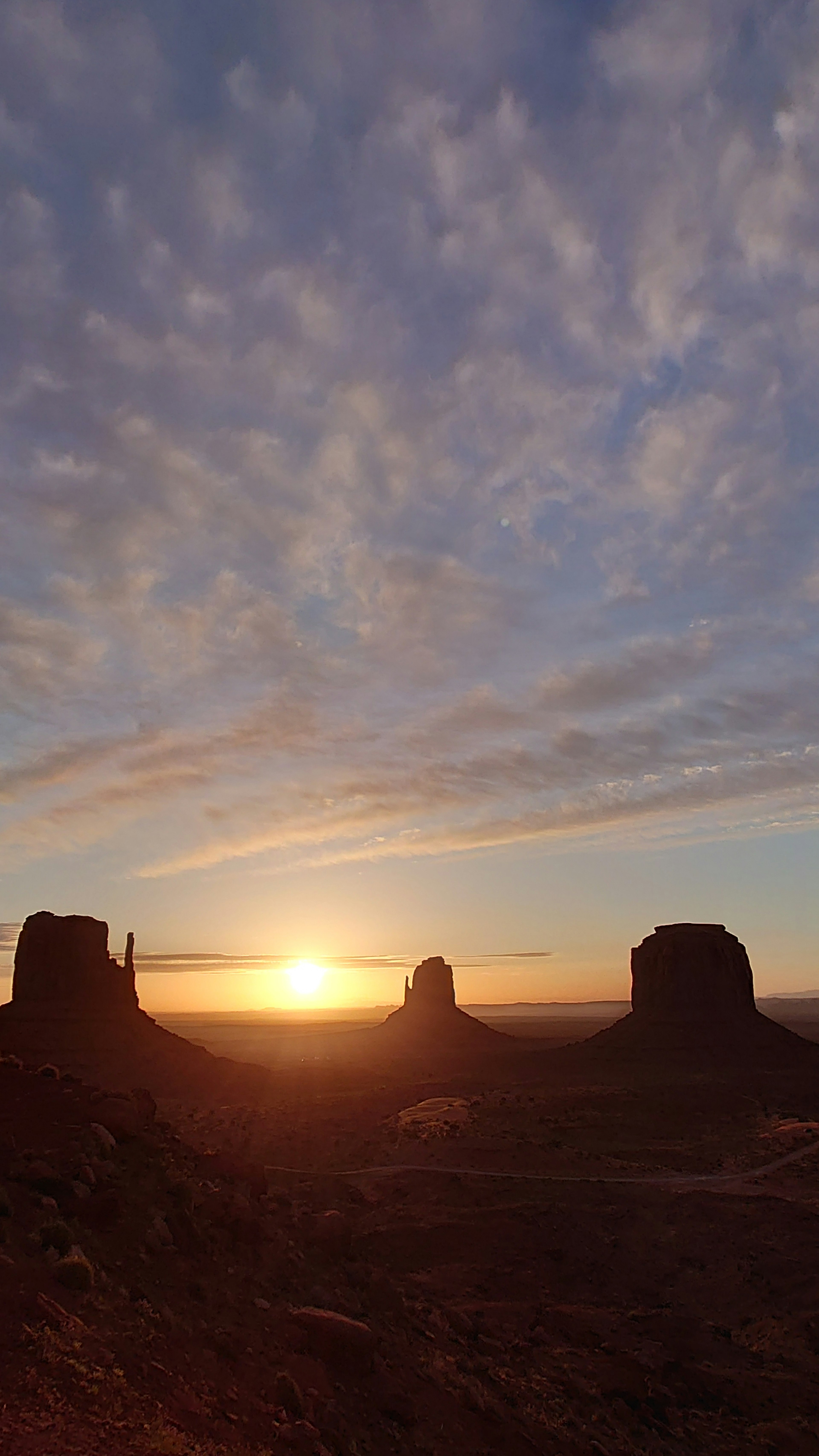 Pemandangan matahari terbenam yang menakjubkan di Monument Valley dengan awan di langit