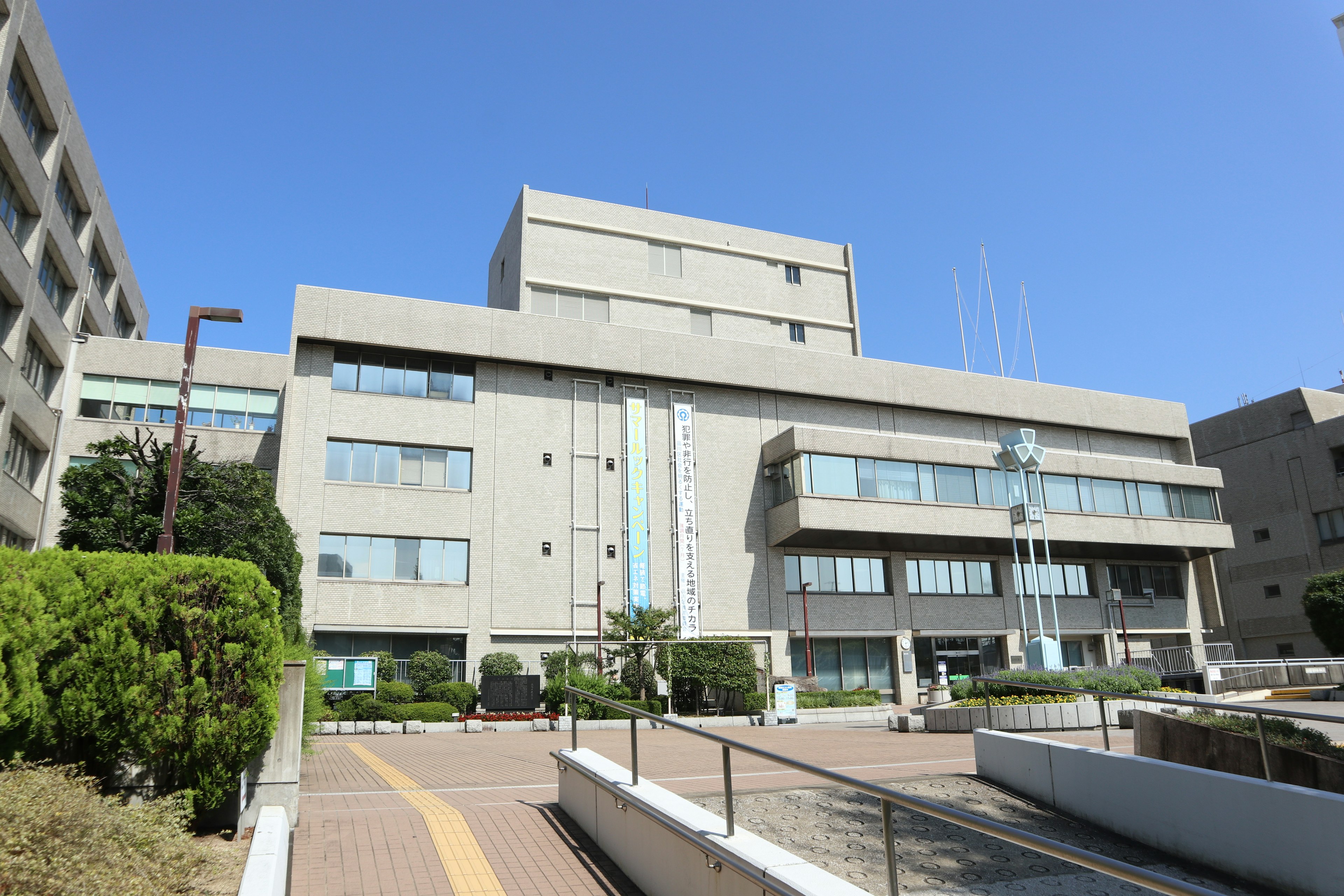 Modern architectural design of a school building under a clear blue sky with surrounding greenery