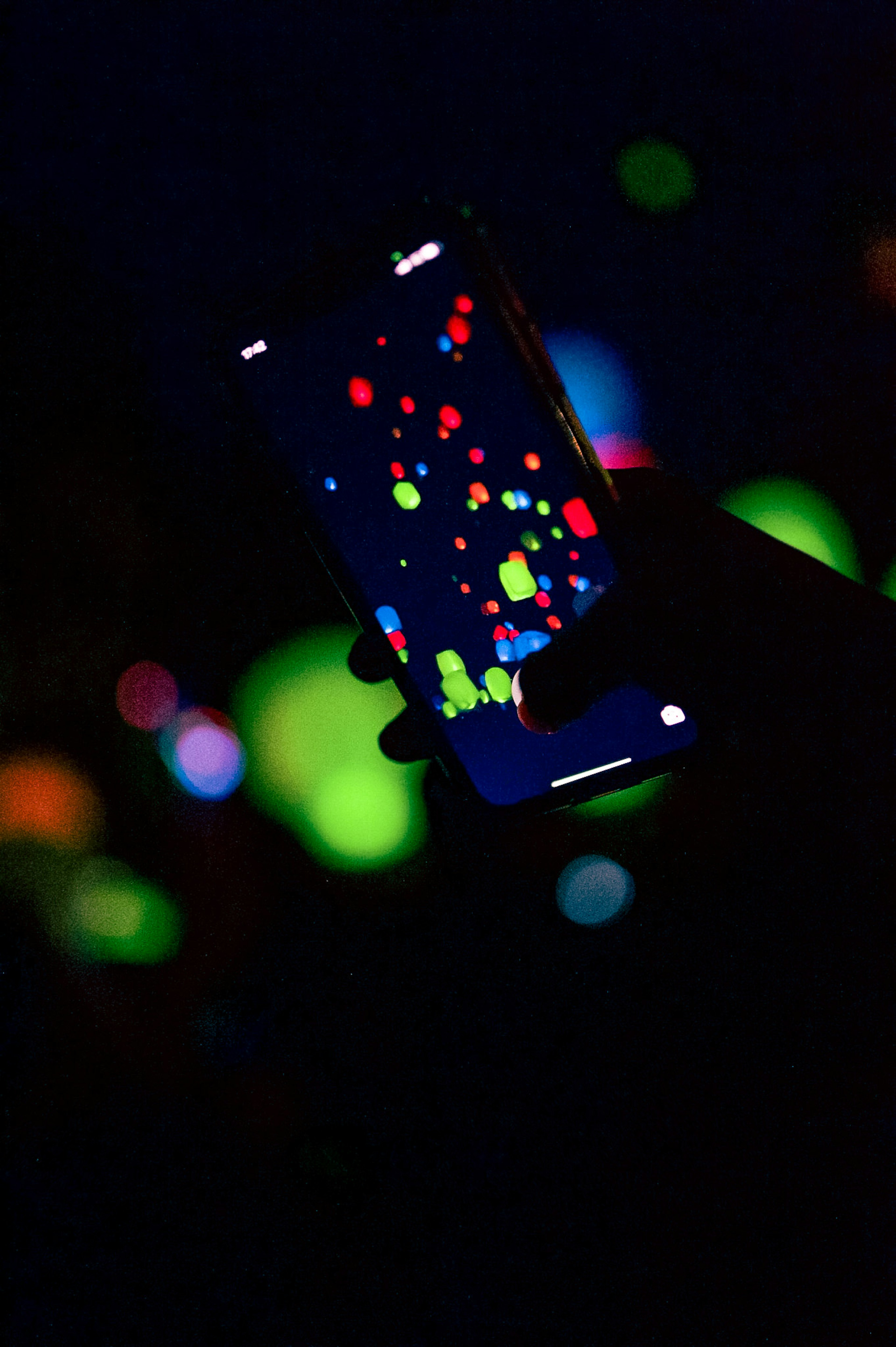 Smartphone screen displaying colorful dots against a dark background