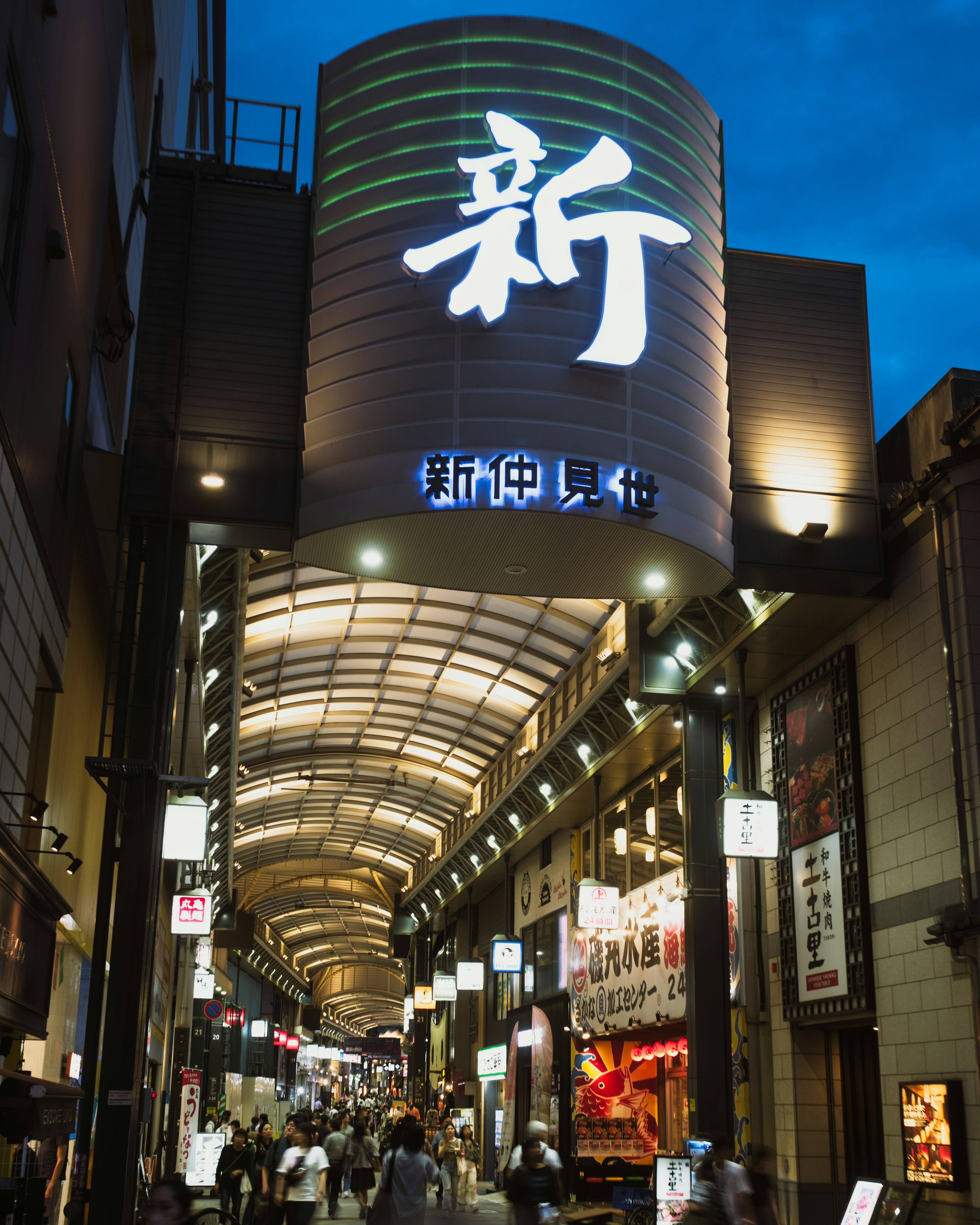 Vue nocturne d'une arcade commerçante avec enseigne lumineuse