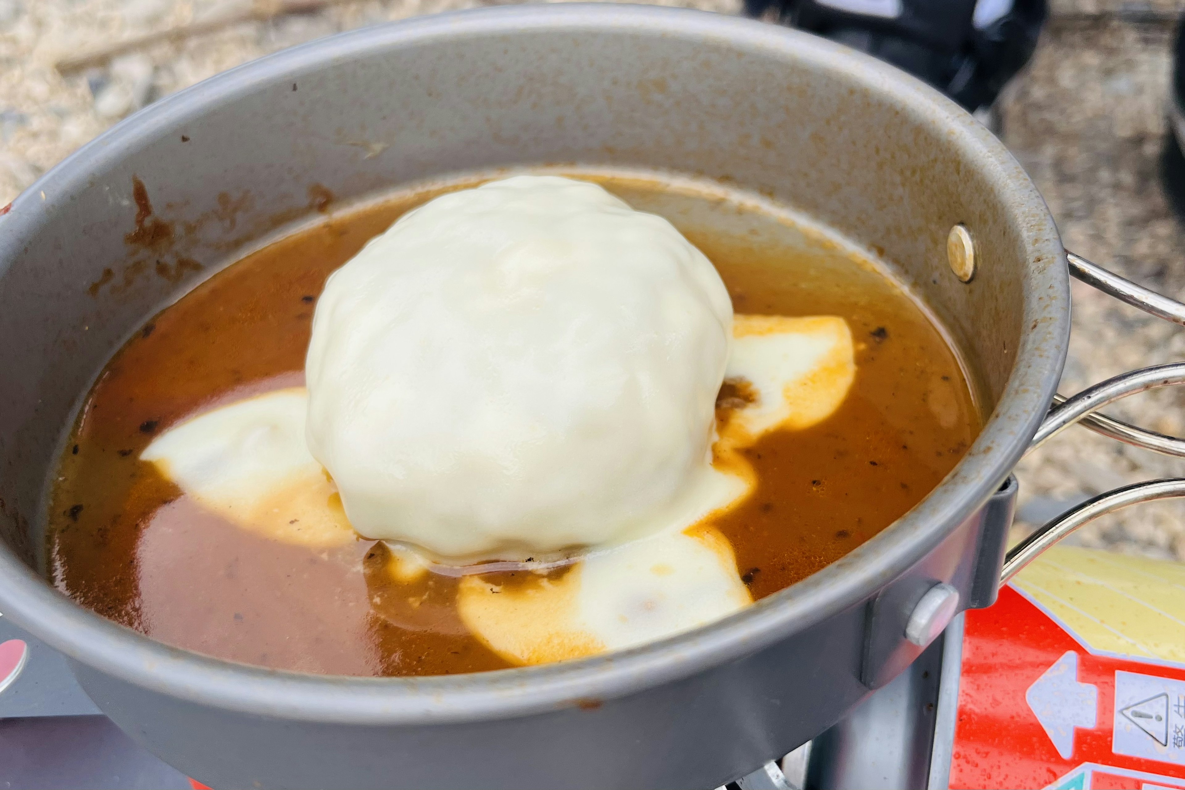 Sebuah panci dengan satu dumpling besar mengapung di dalam sup