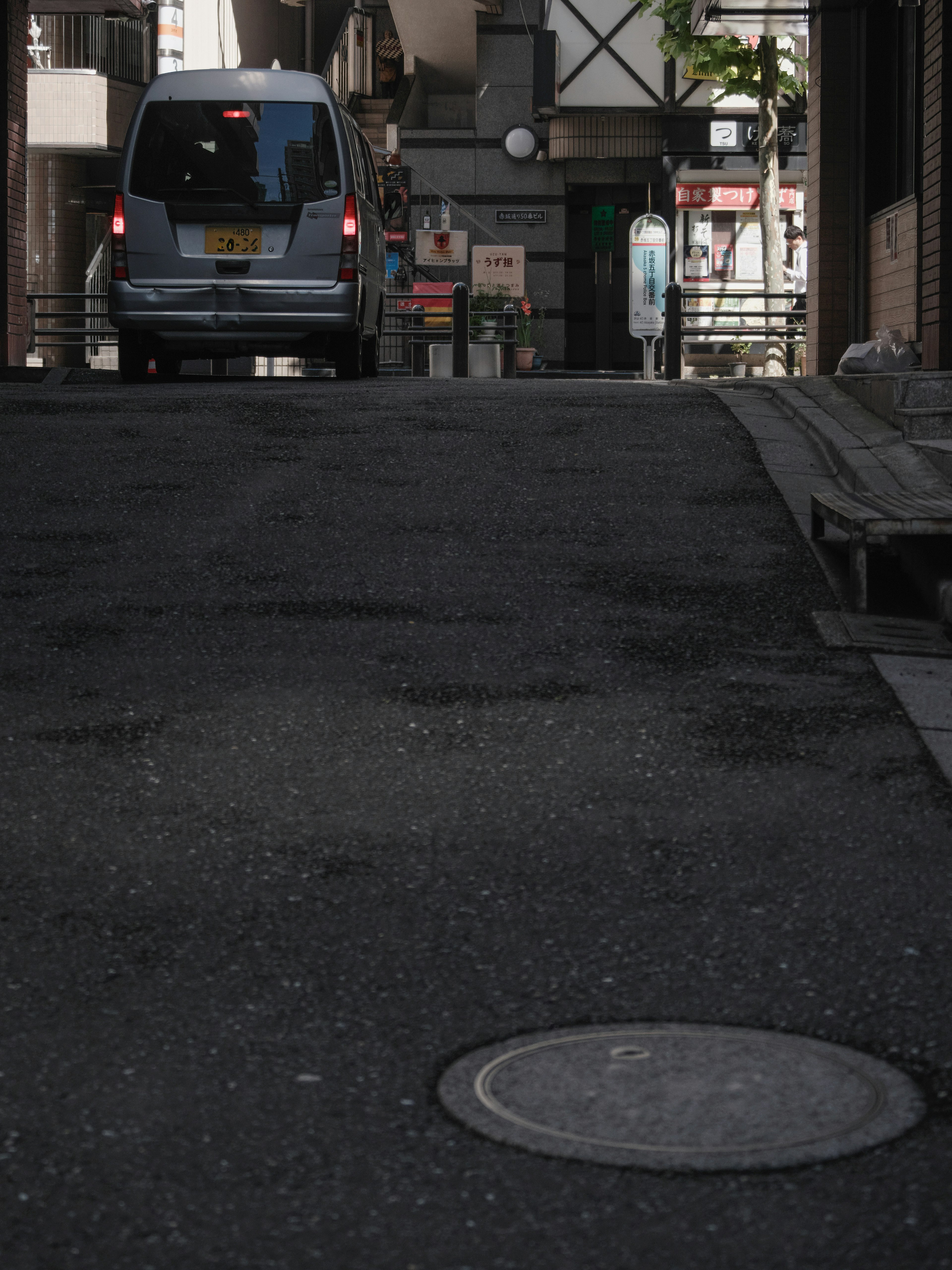 Un véhicule garé dans une rue étroite avec un regard