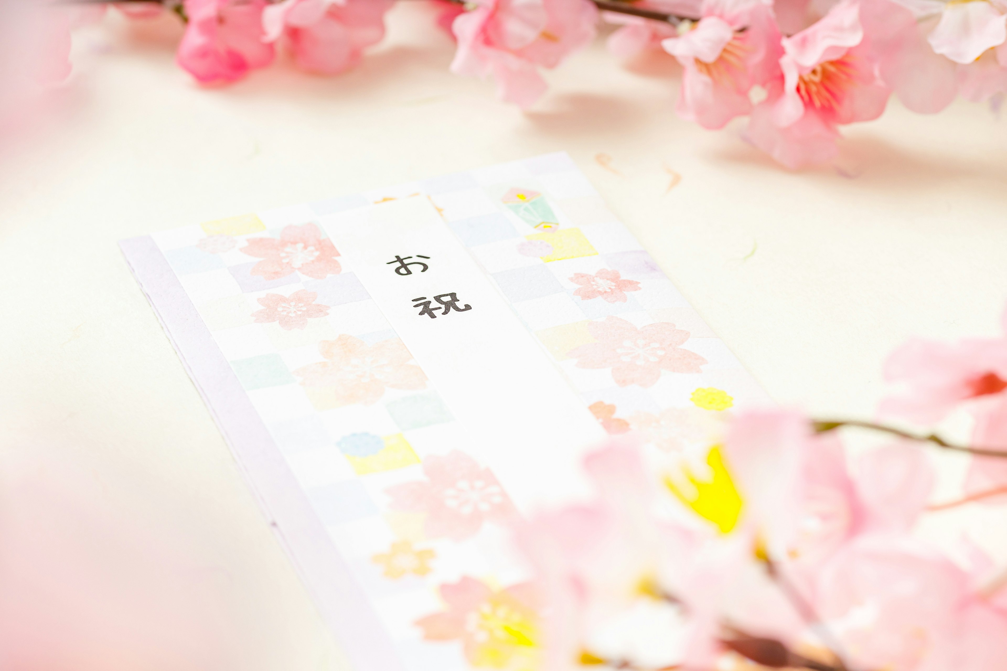 A celebration card surrounded by cherry blossom petals