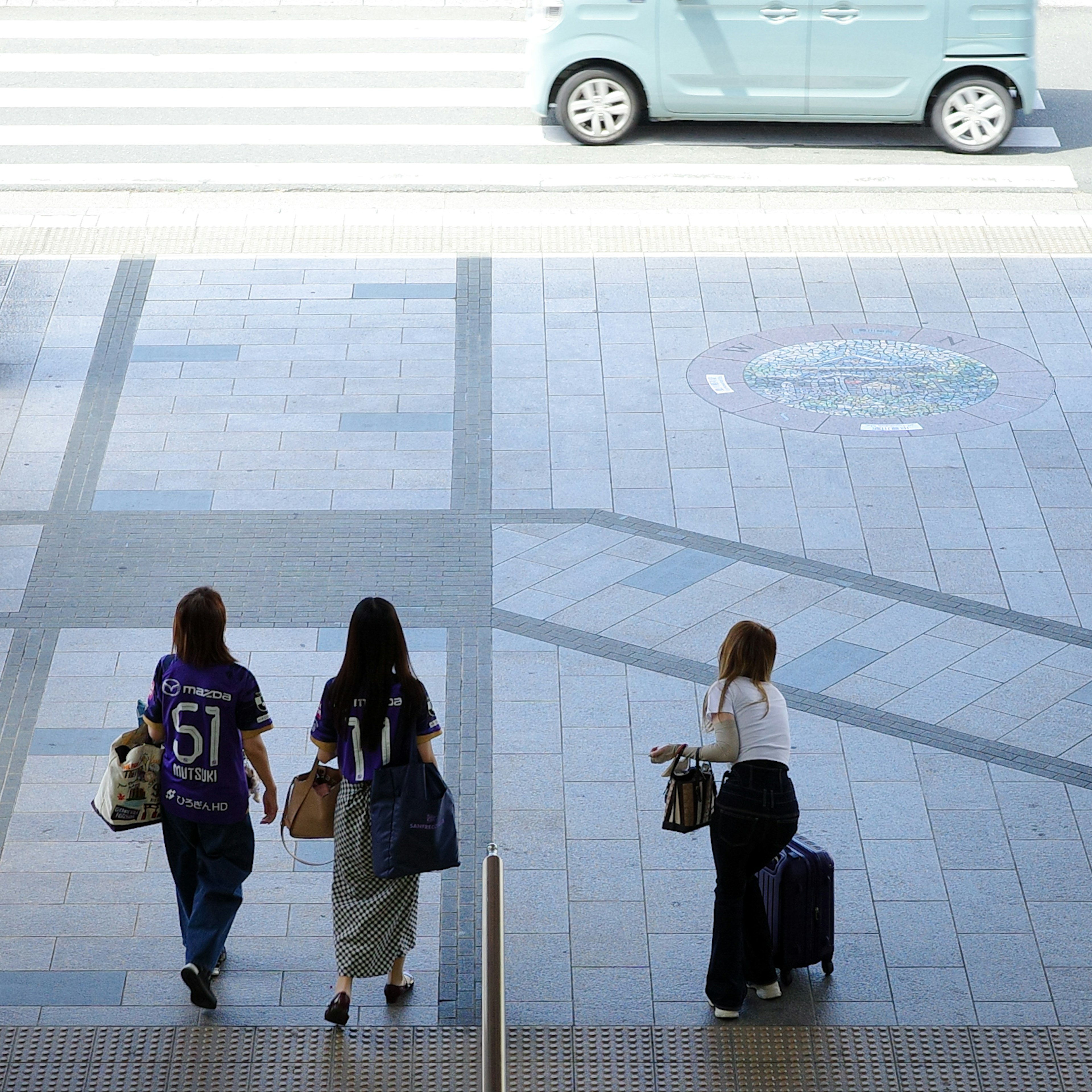 女性たちがショッピングバッグを持って歩いている街の風景