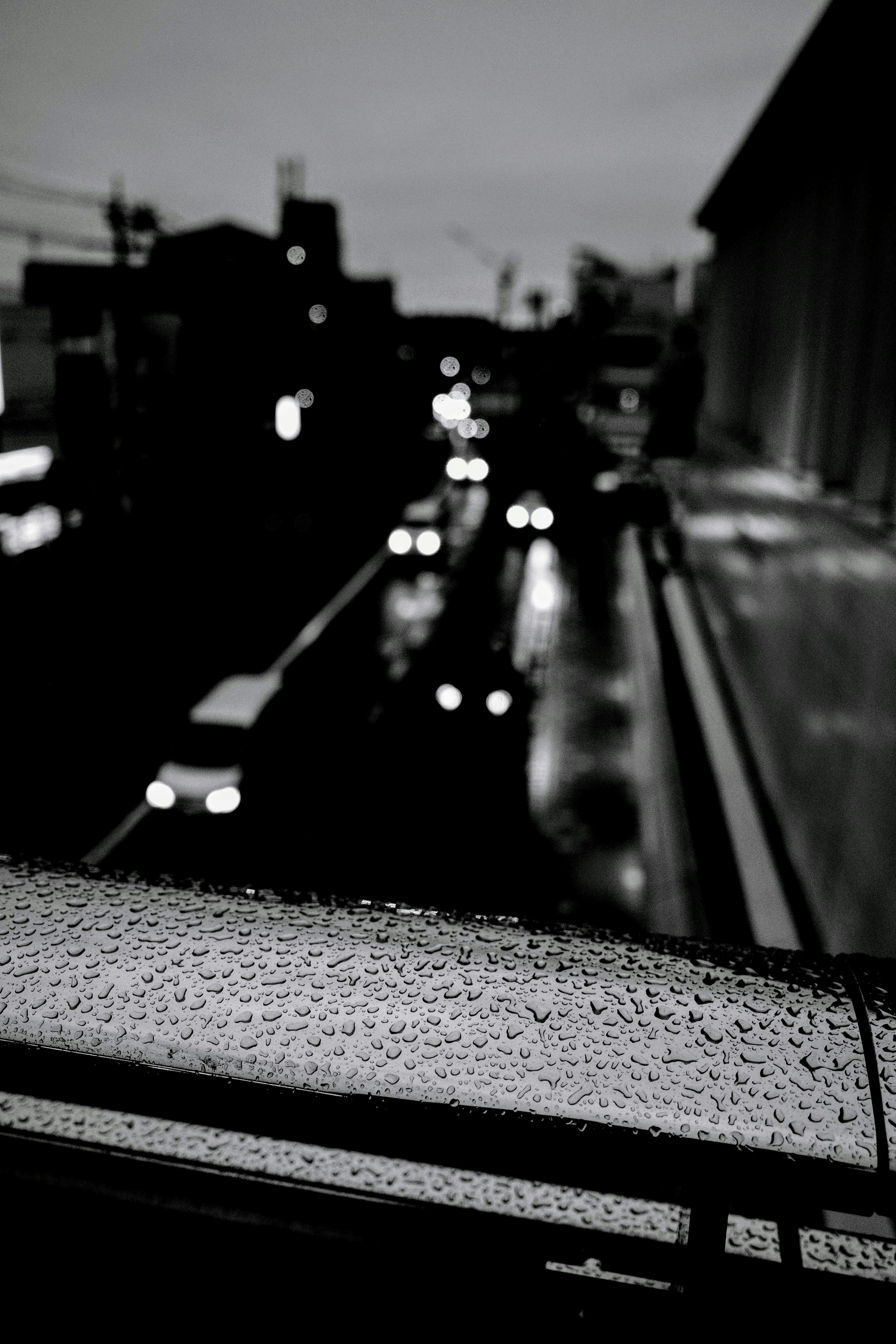 雨に濡れた手すりとぼやけた街の風景を背景にした夜の写真