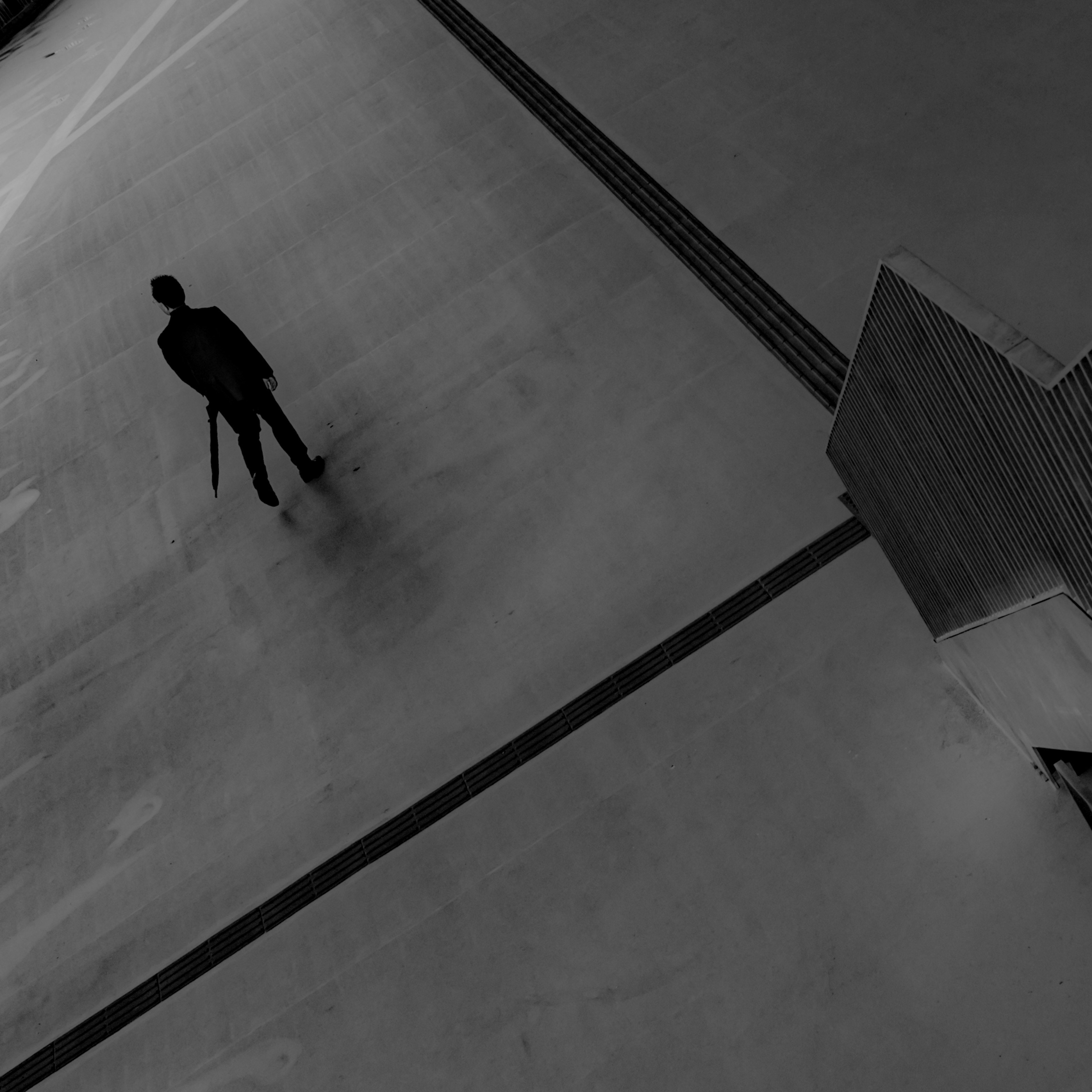 Silhouette d'une personne se tenant dans un espace monochrome avec un design linéaire