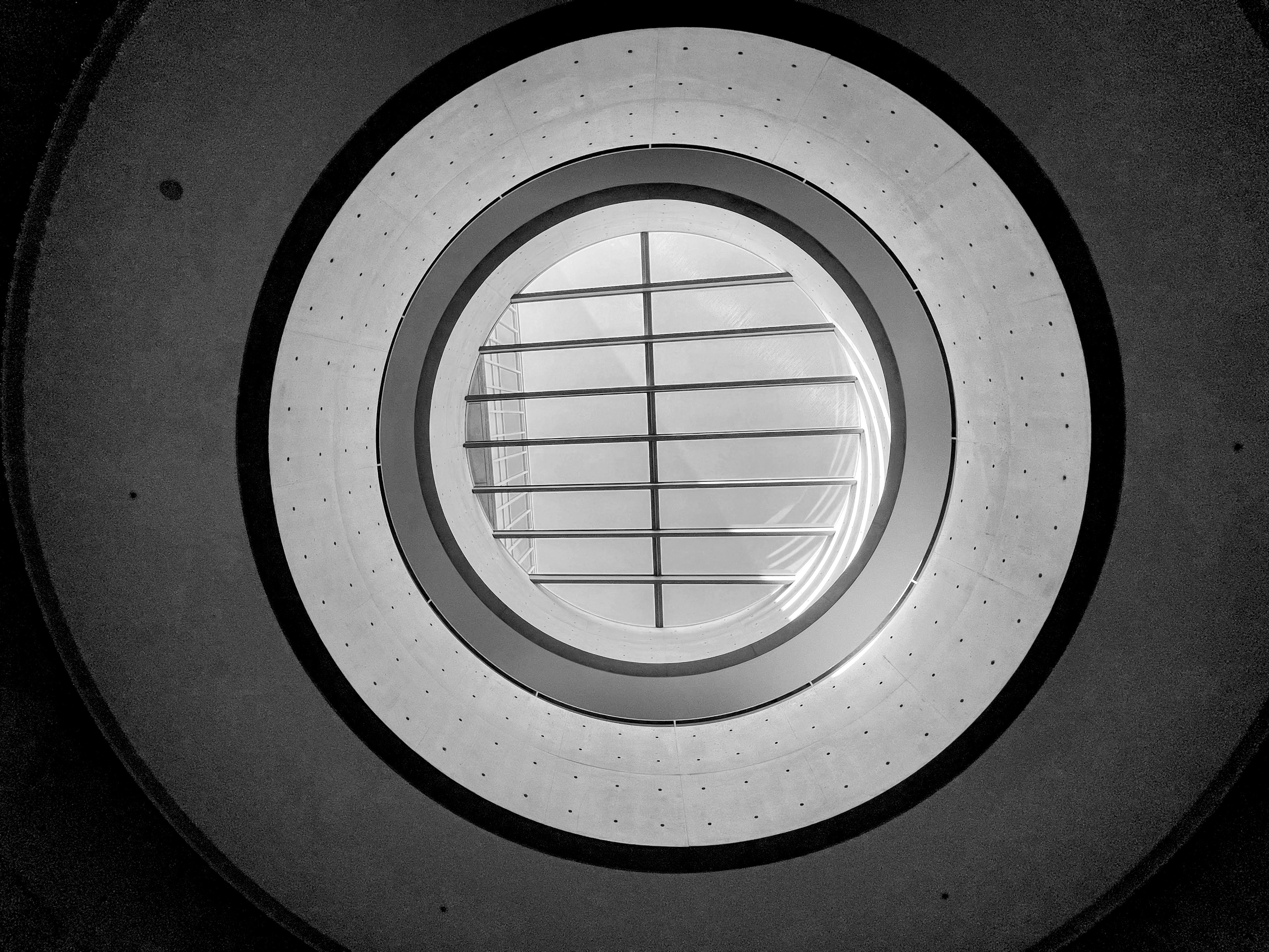 Circular view of a staircase through a round window with grid pattern