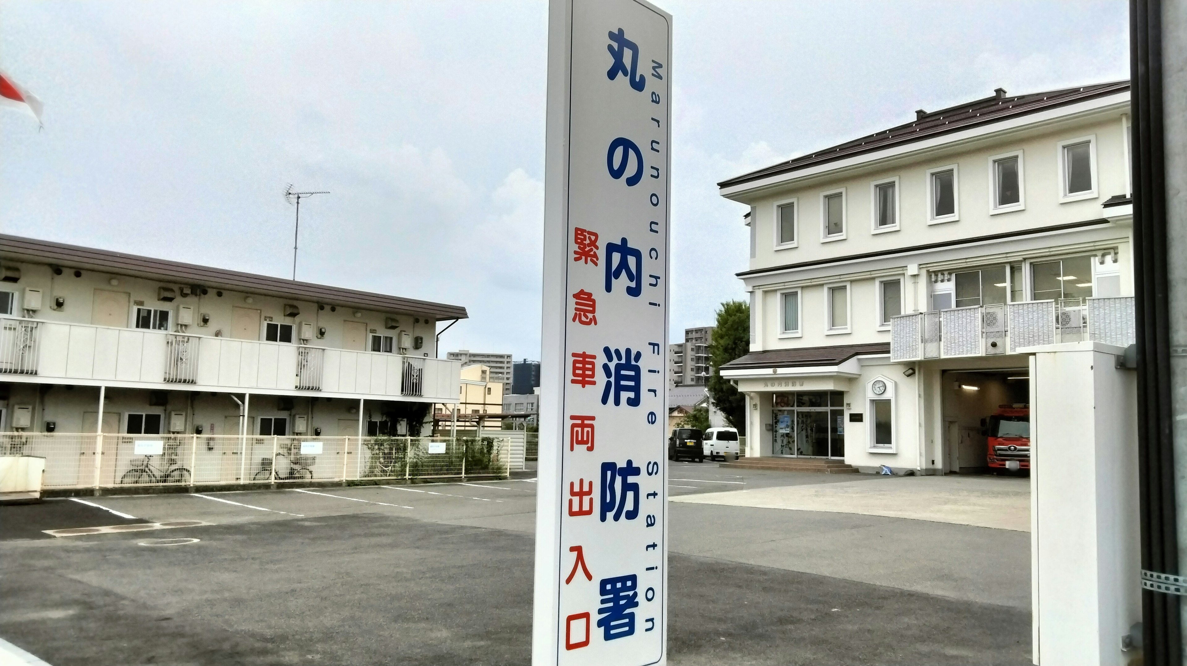 Cartello che indica l'ingresso degli impianti di sicurezza antincendio con un edificio bianco