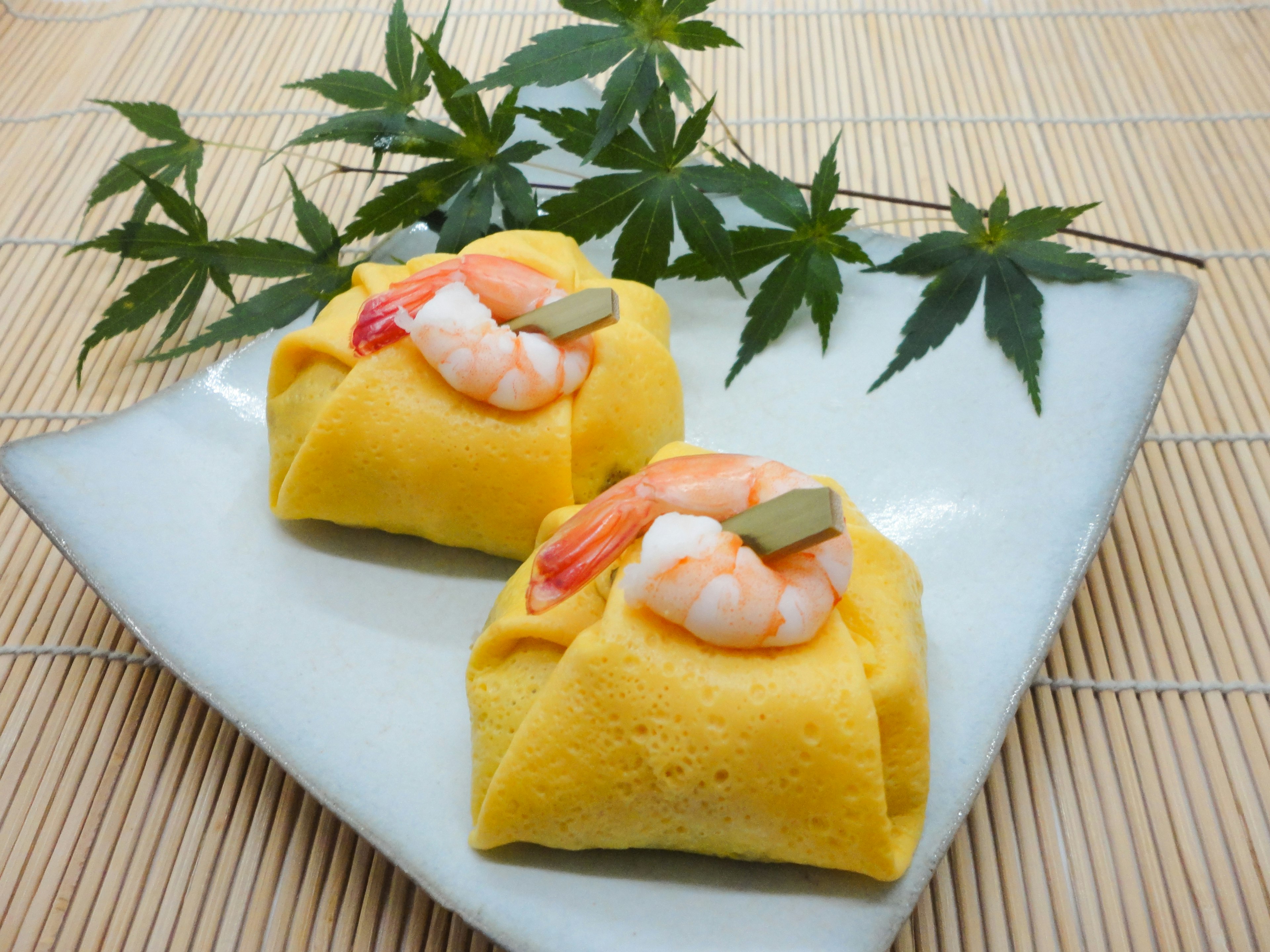 Deux pièces d'omelette aux crevettes sur une assiette blanche