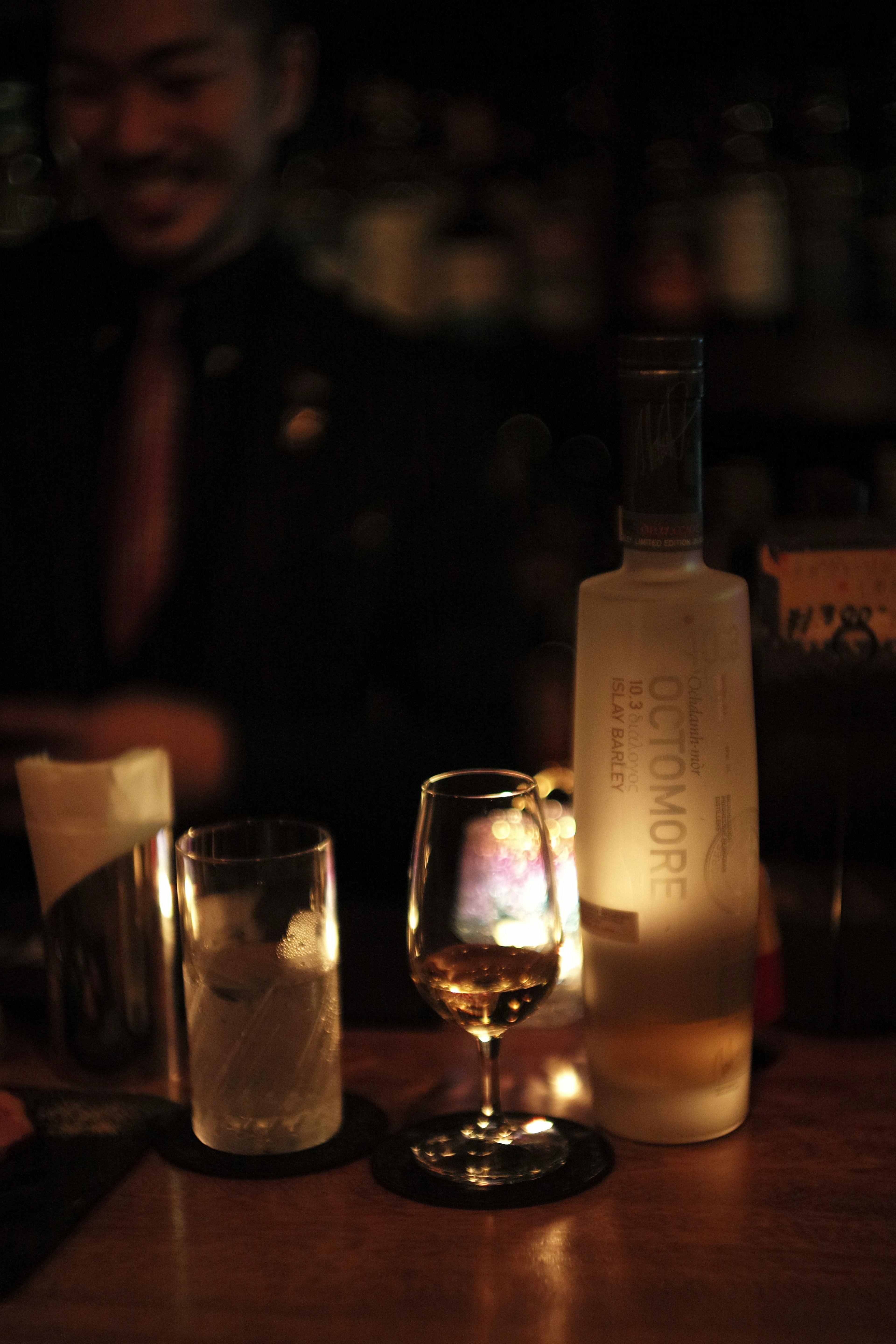 A dimly lit bar scene featuring various cocktails on the table