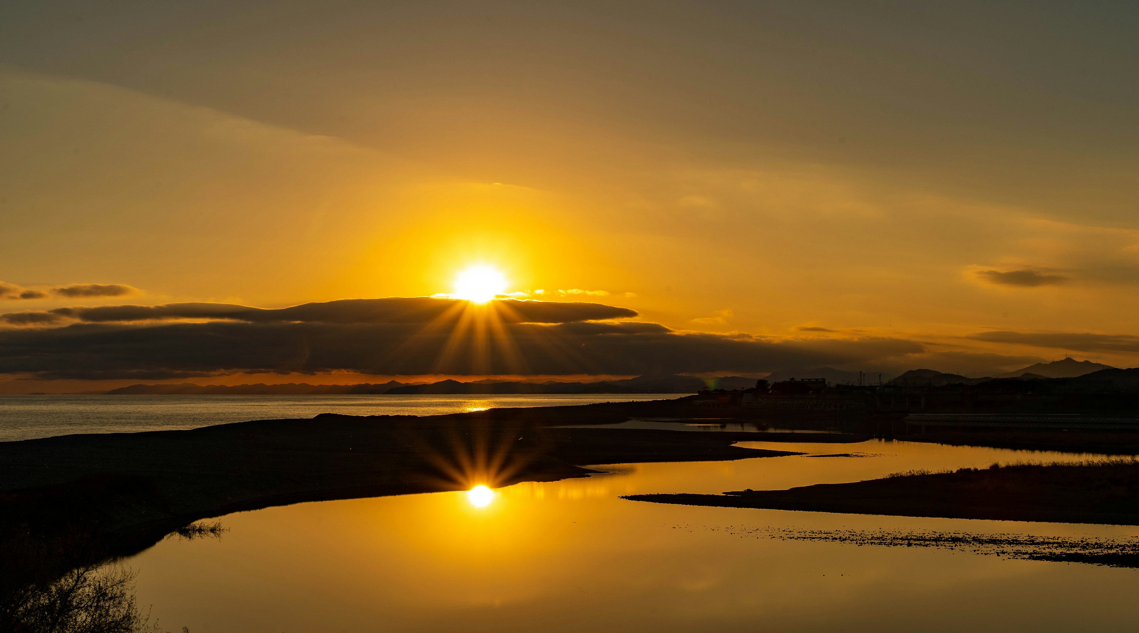 Schöne Landschaft mit Sonnenuntergang, der sich im Wasser spiegelt