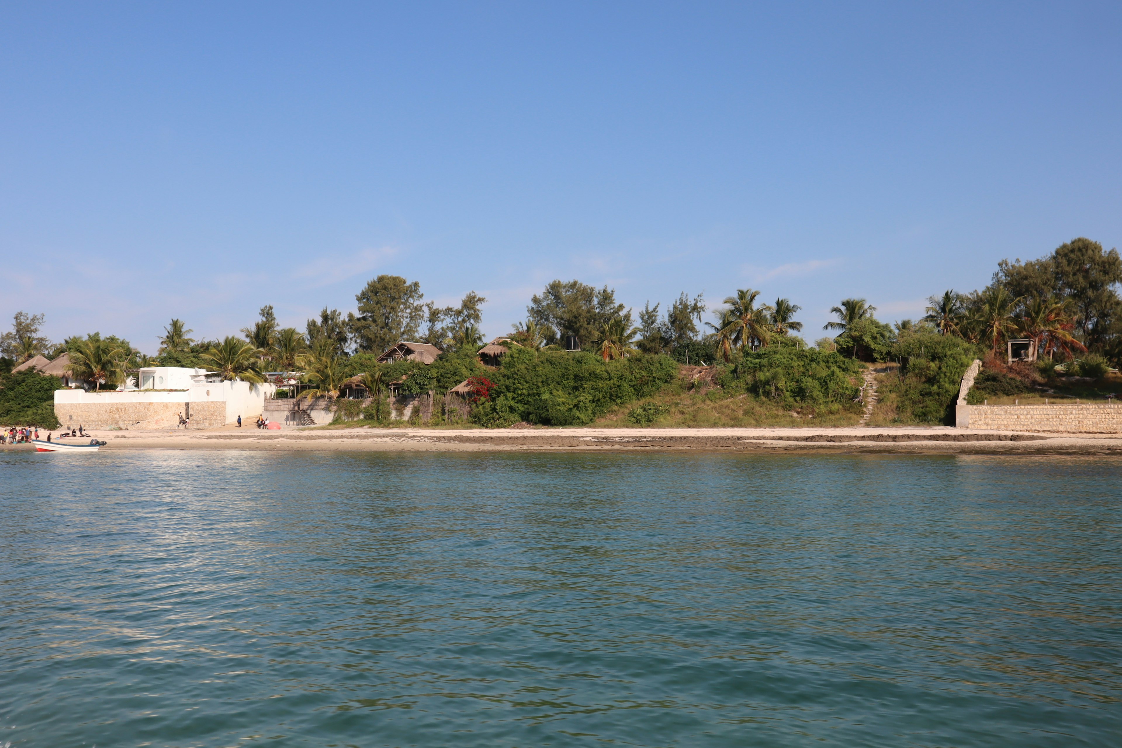 Ruhige See mit üppigem Grün entlang des Strandes