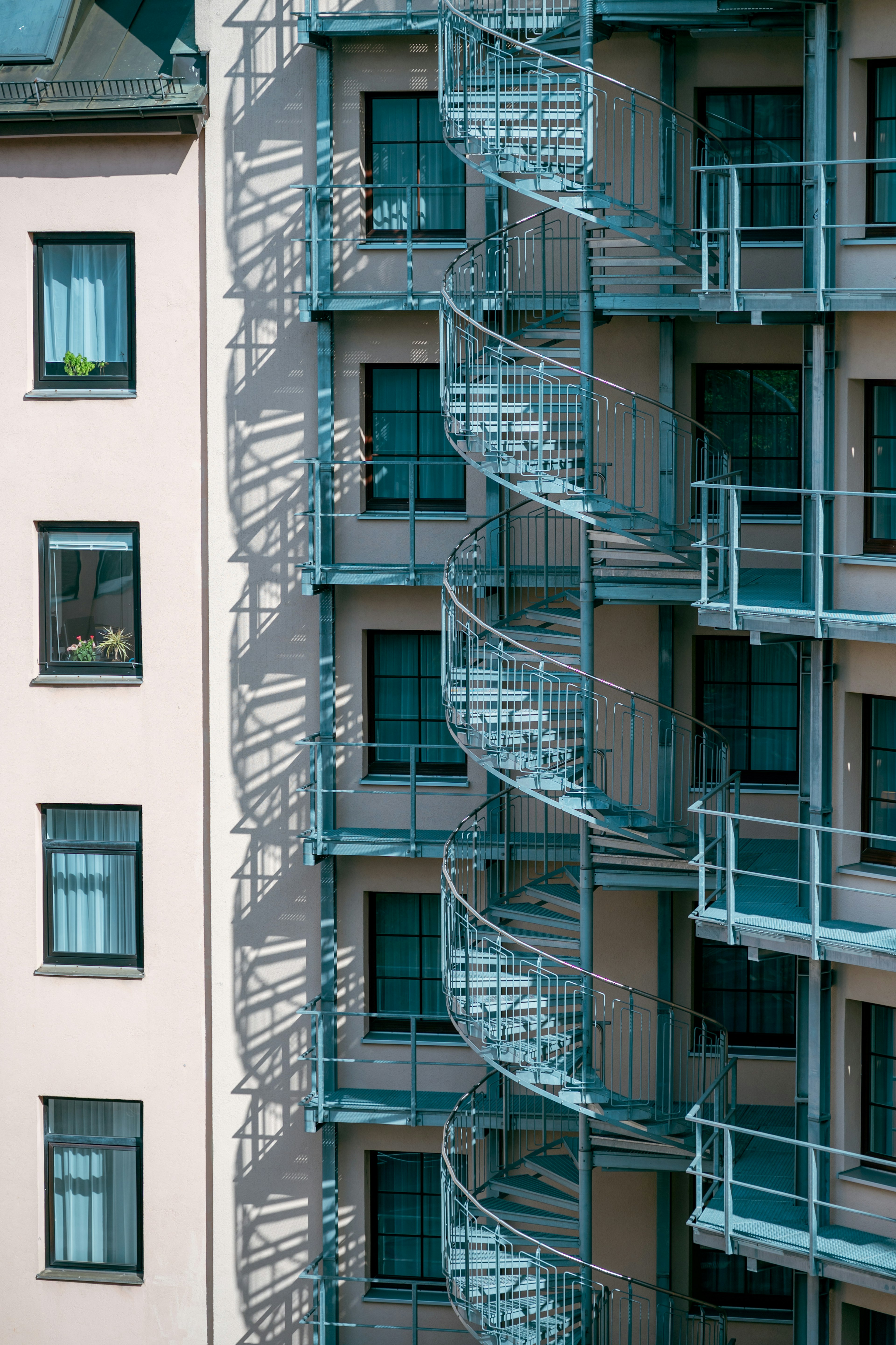 Façade d'un bâtiment moderne avec un escalier en spirale bleu