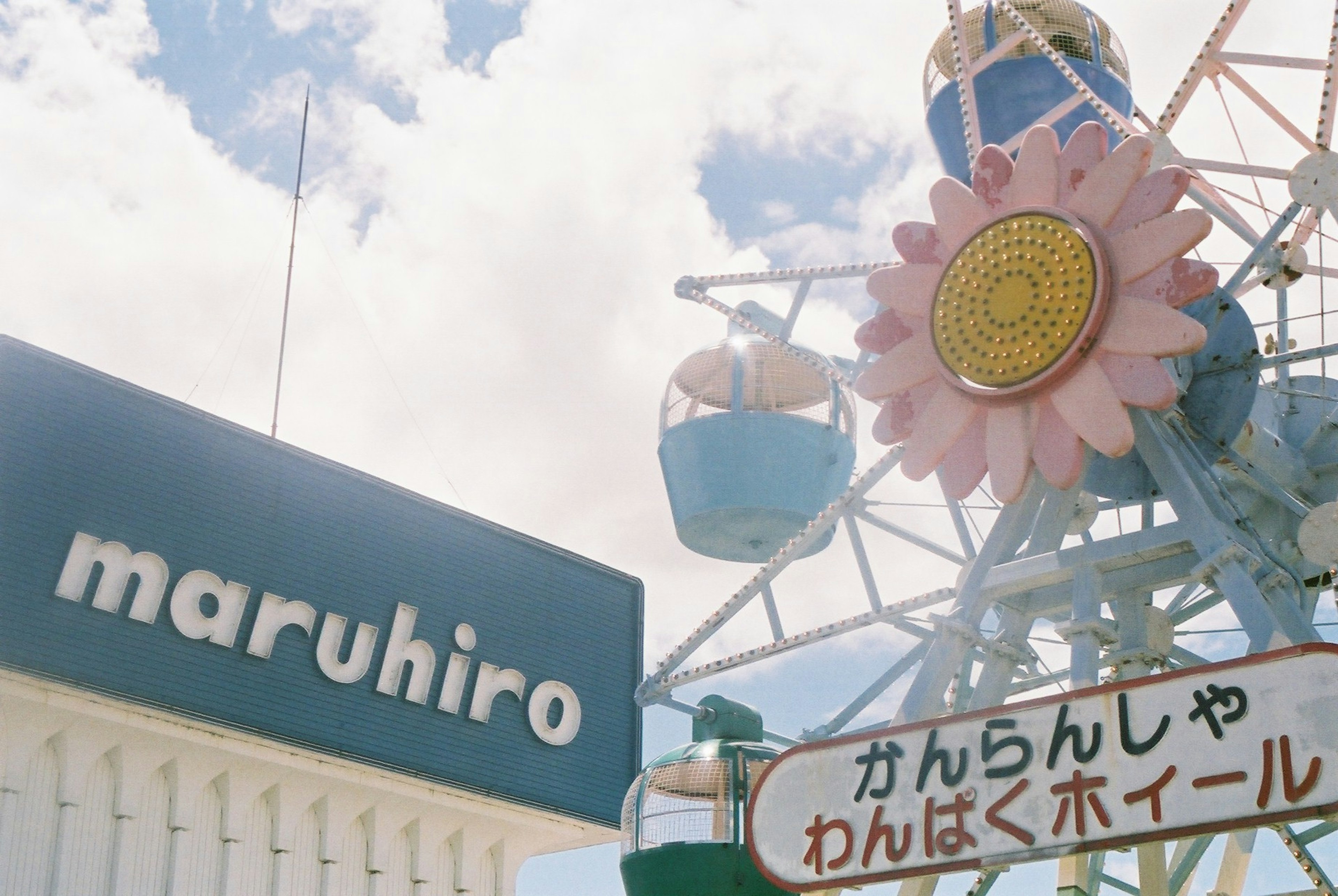 Cartel del parque de diversiones Maruhiro con una noria