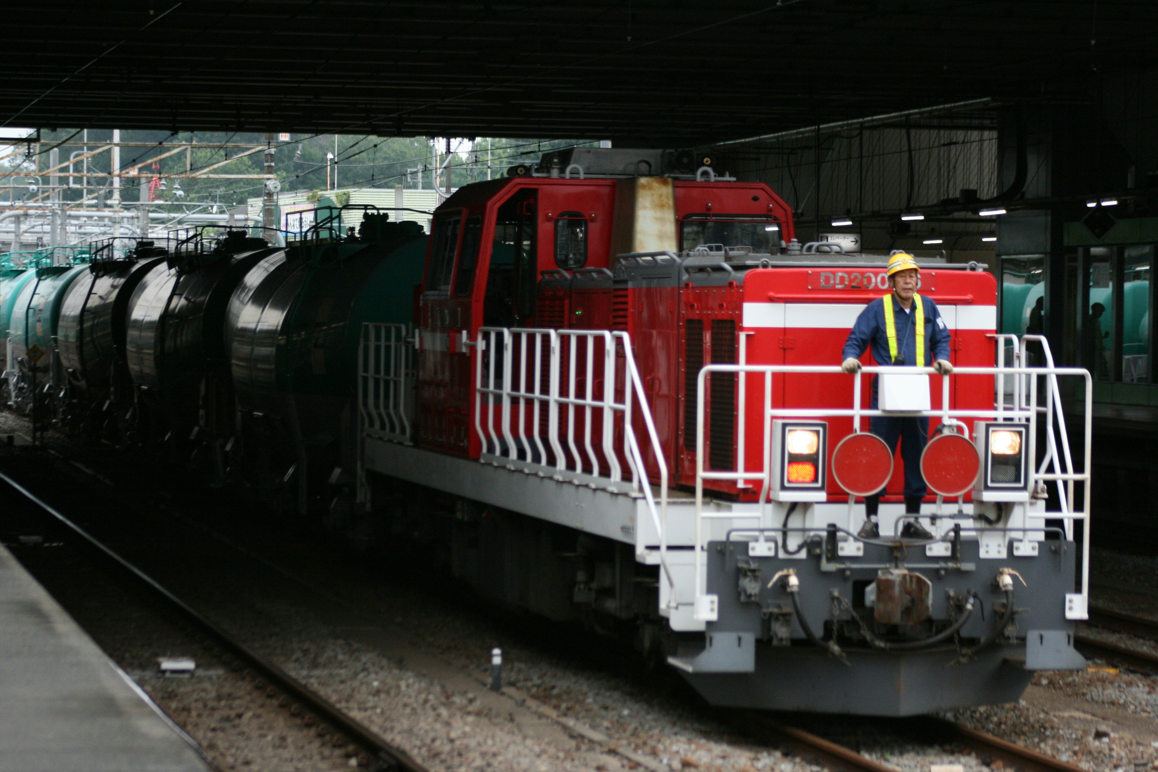 Locomotive rouge tirant un train de marchandises à une gare