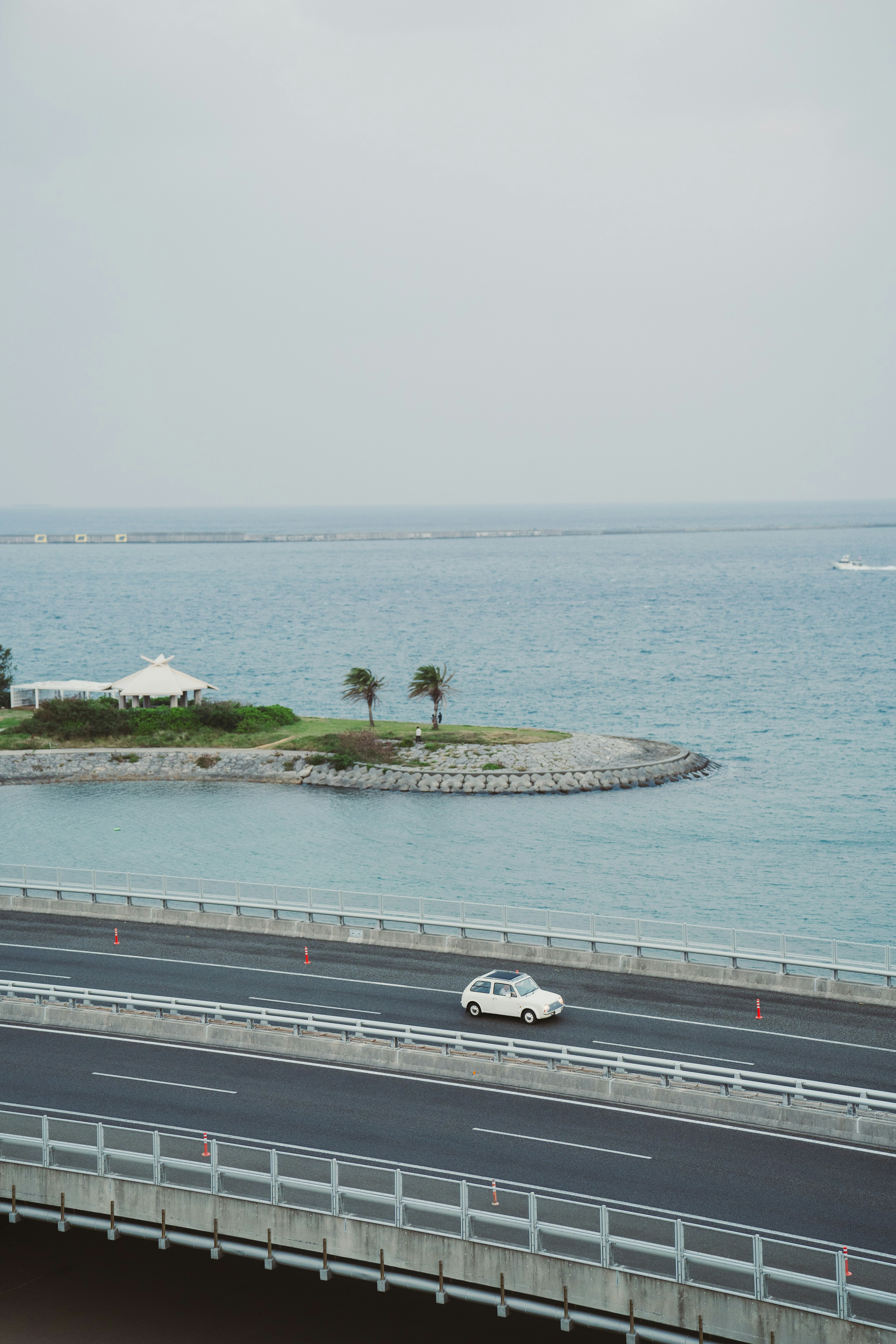 Vue de la mer et de la route petite île avec des palmiers voiture blanche en circulation