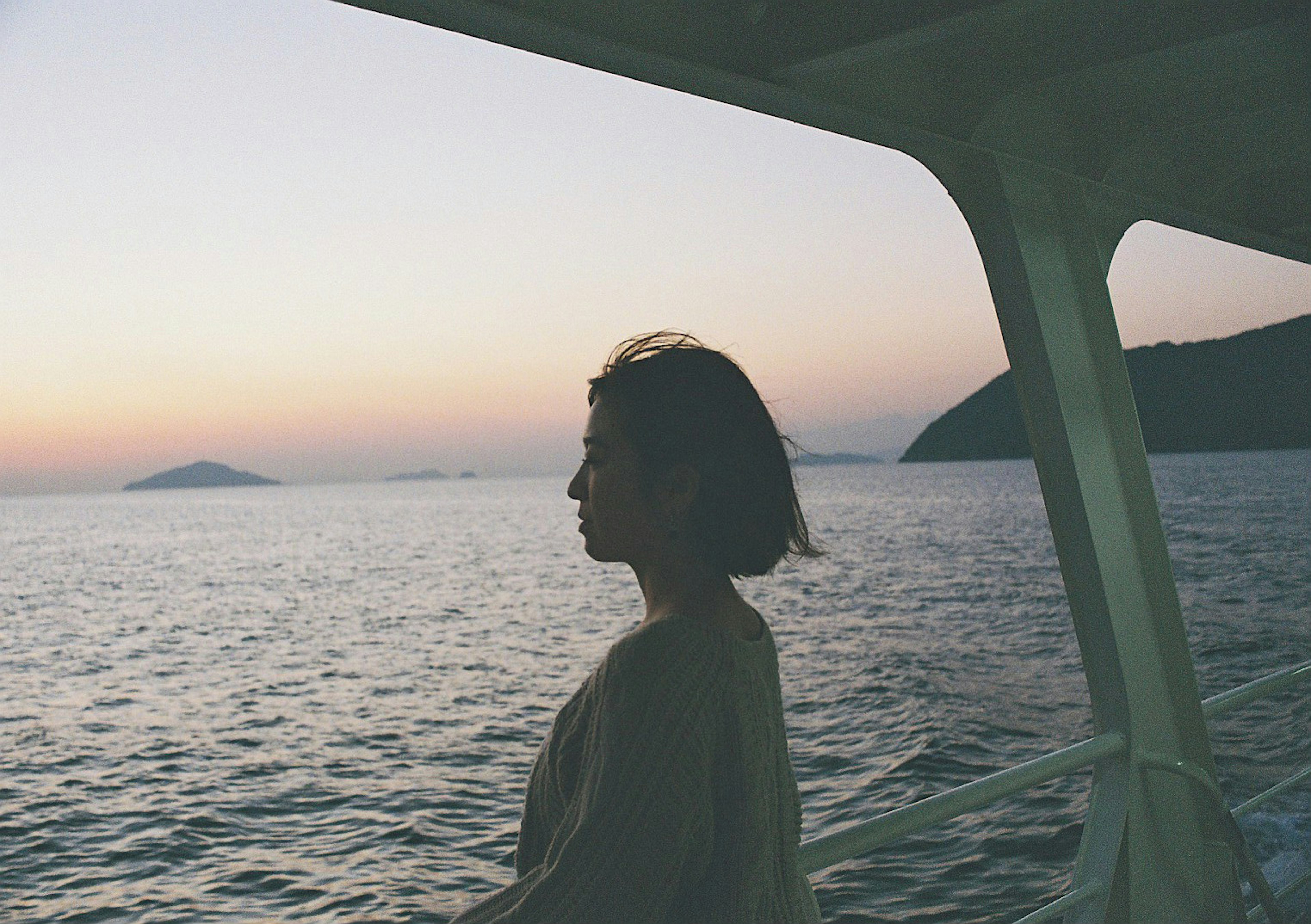 Silhouette di una donna contro un mare al tramonto