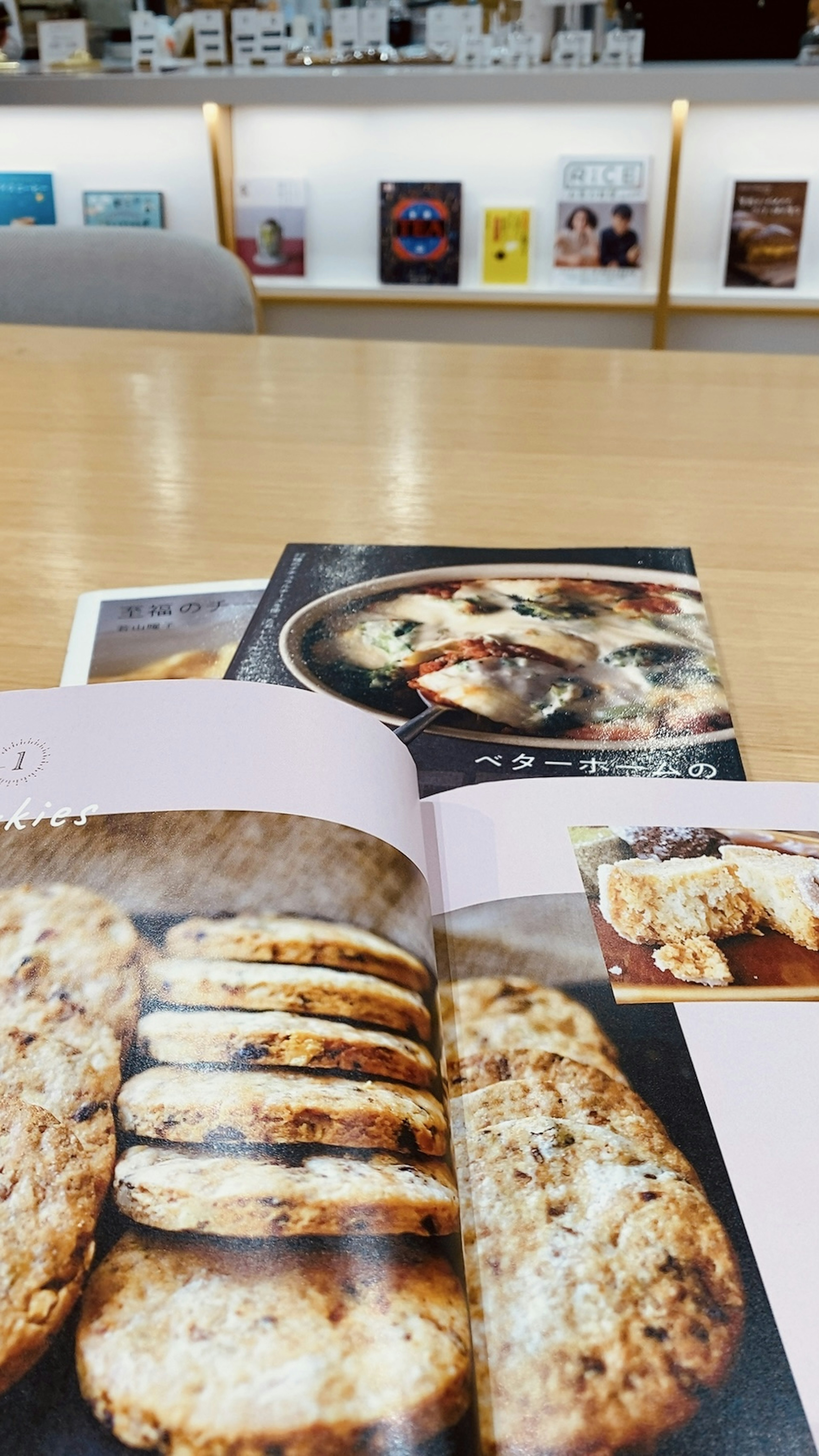 A cookbook opened to a page featuring freshly baked bread on a wooden table