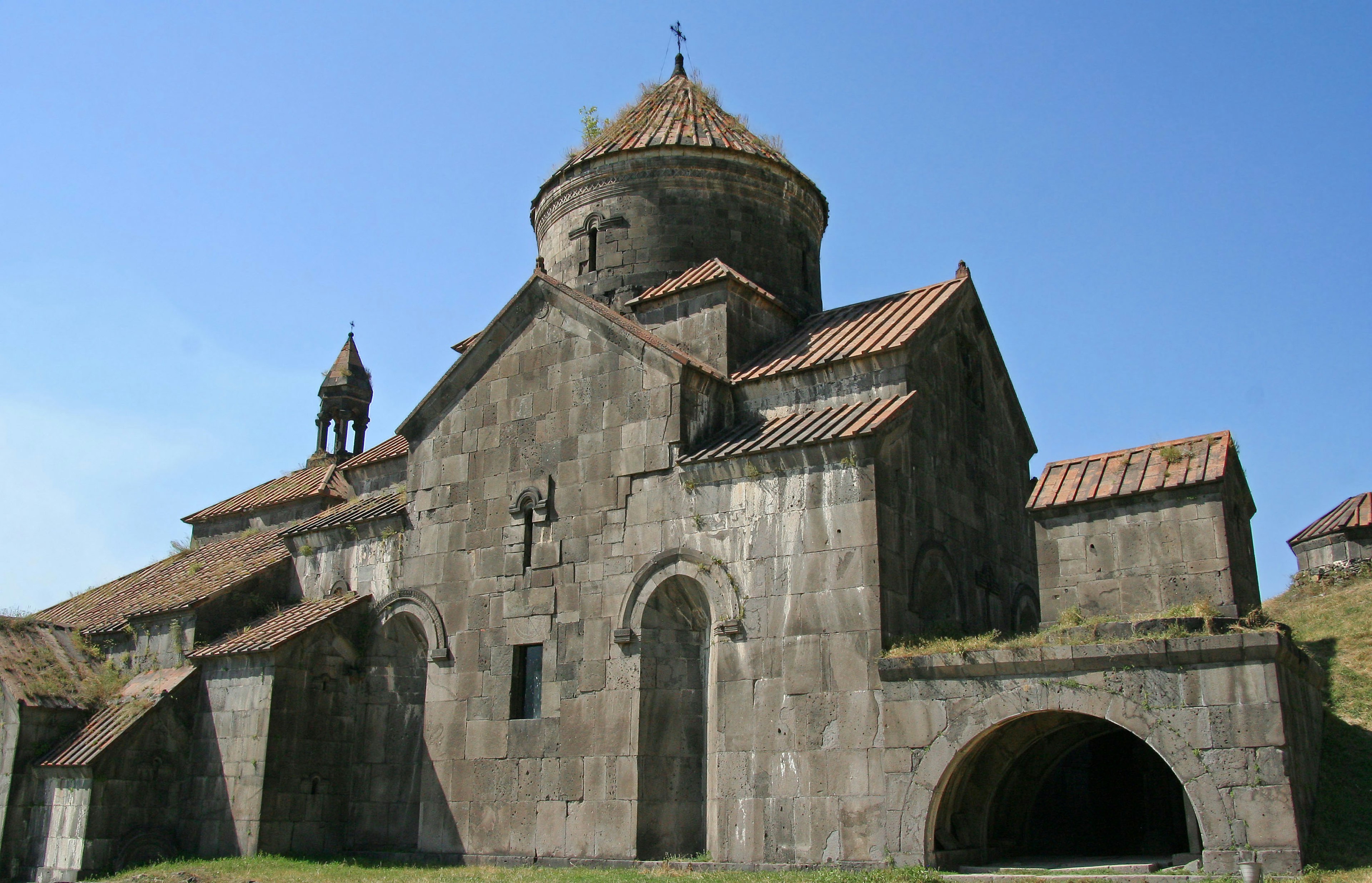 Ancient stone church with tiled roof under blue sky showcasing historical architecture