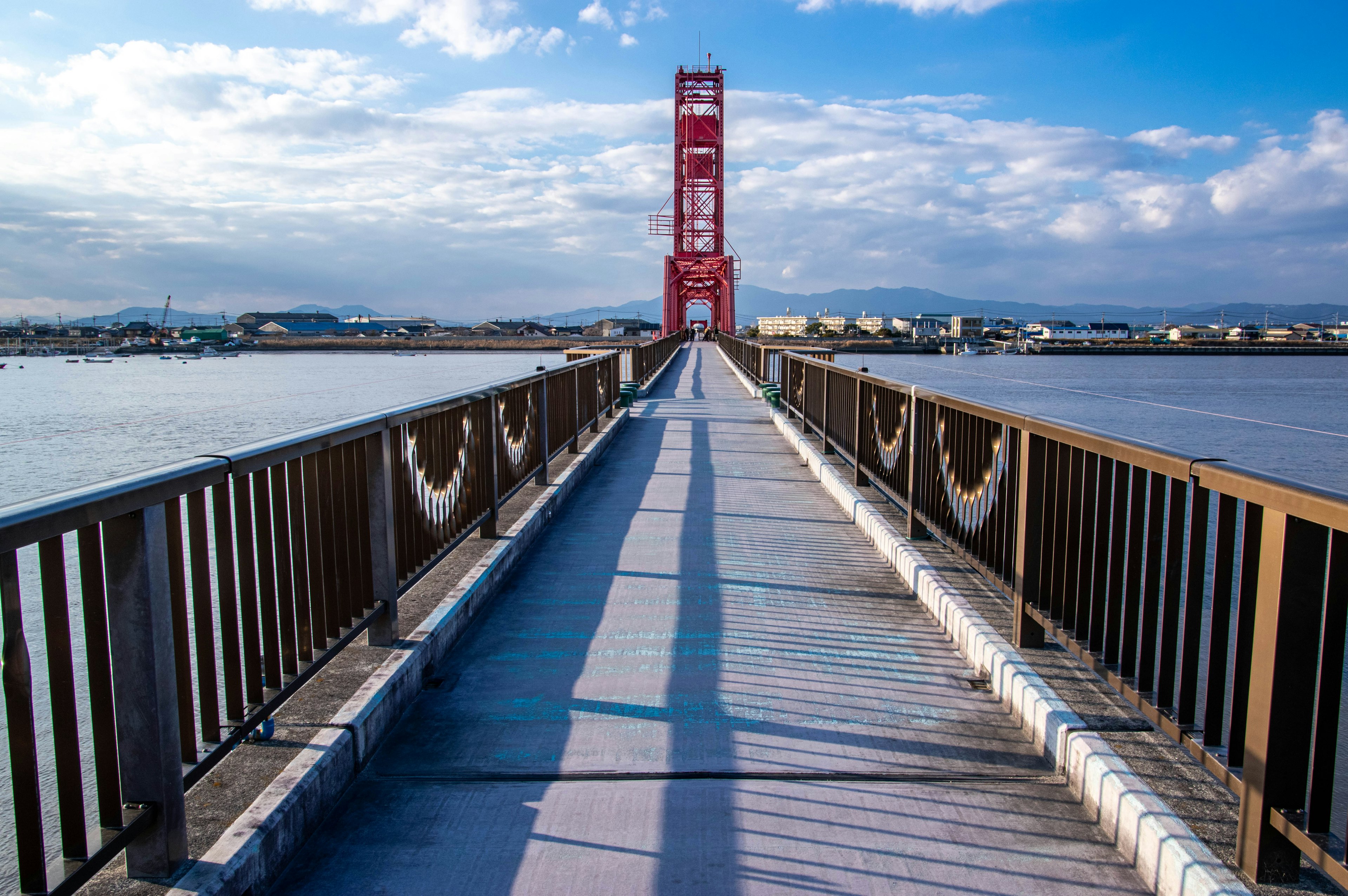 Vue pittoresque d'un pont avec une tour rouge ciel bleu clair et nuages