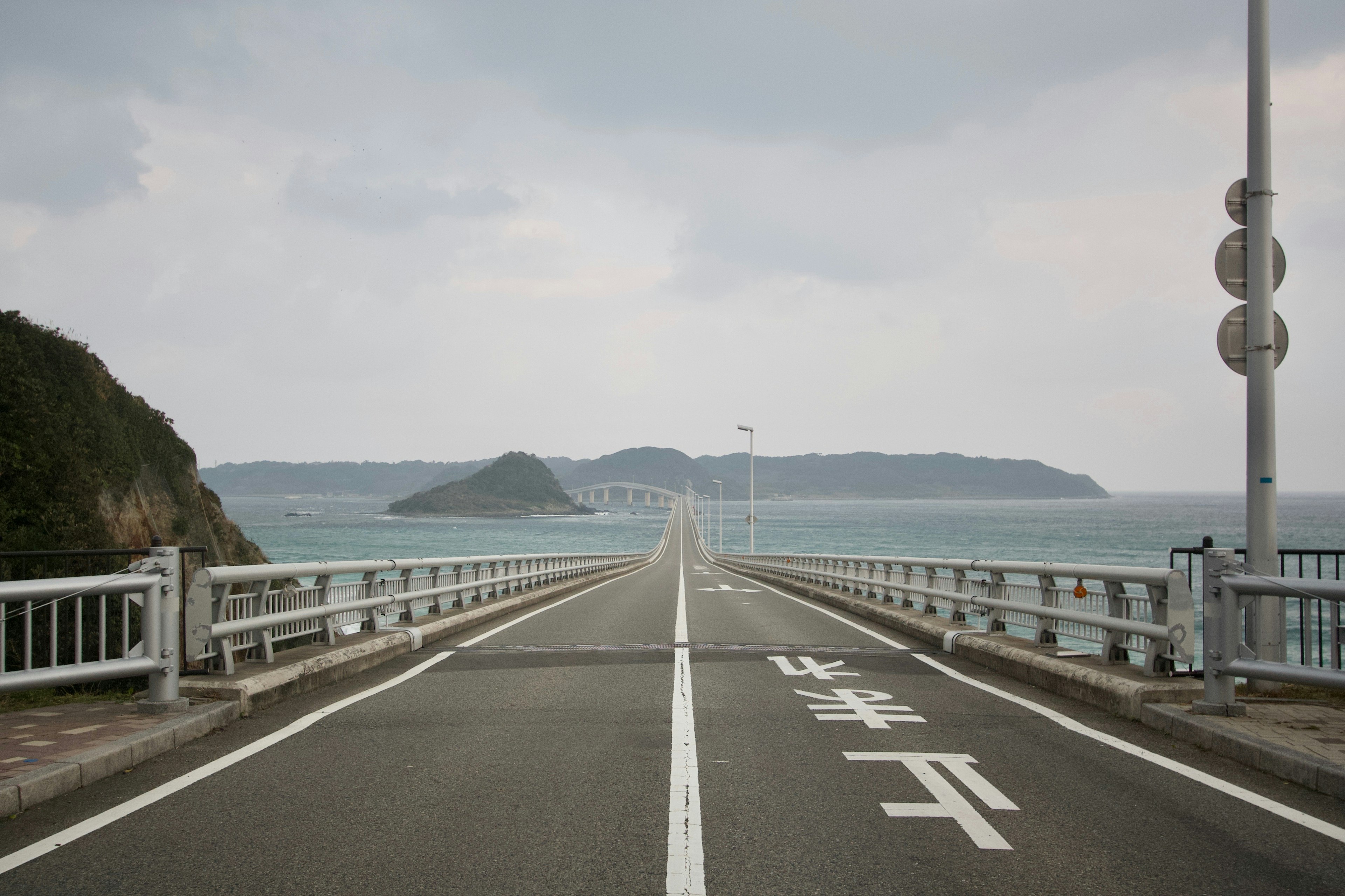 一条通向大海的道路，背景有一座桥