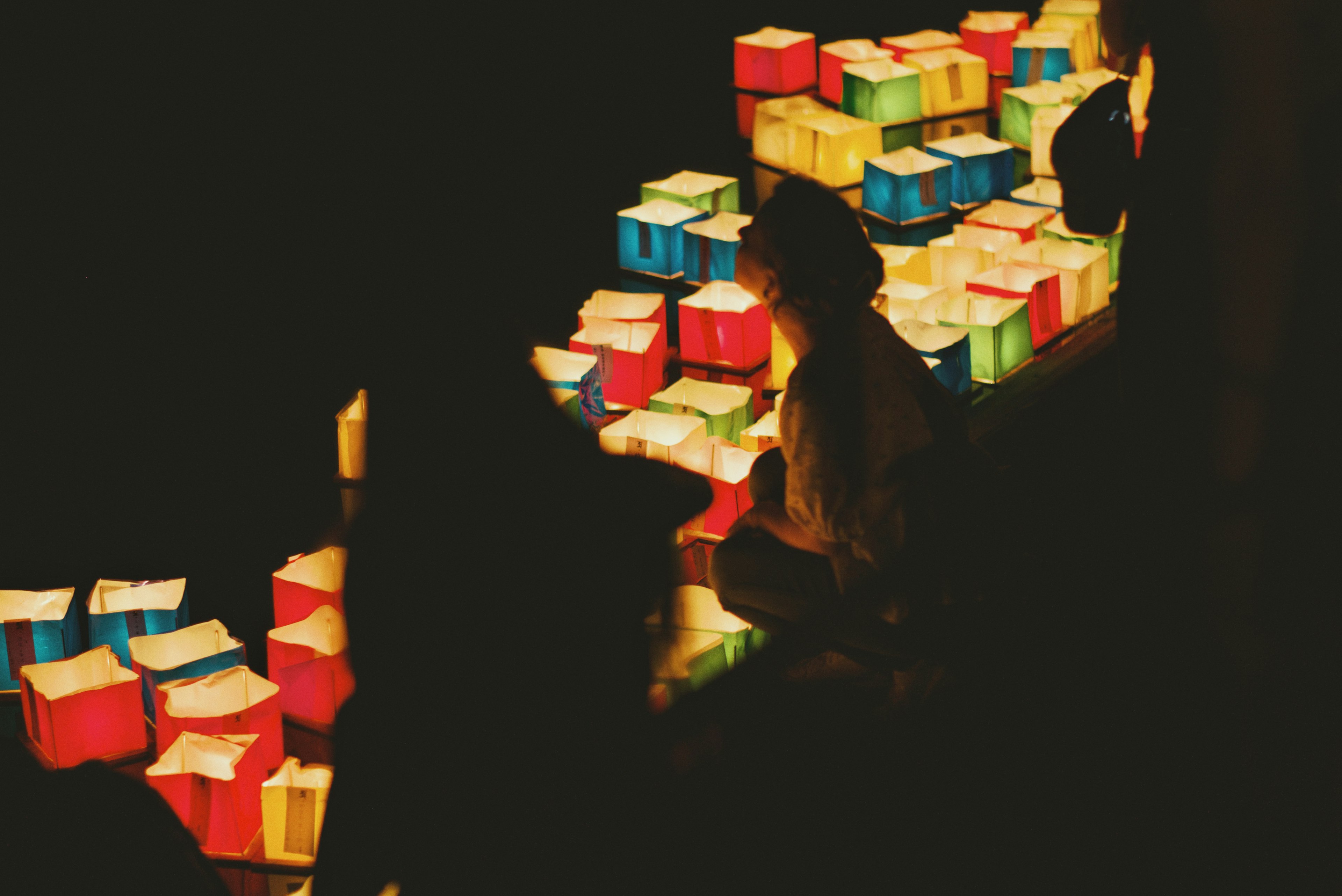 Silhouette of a person surrounded by colorful boxes against a dark background