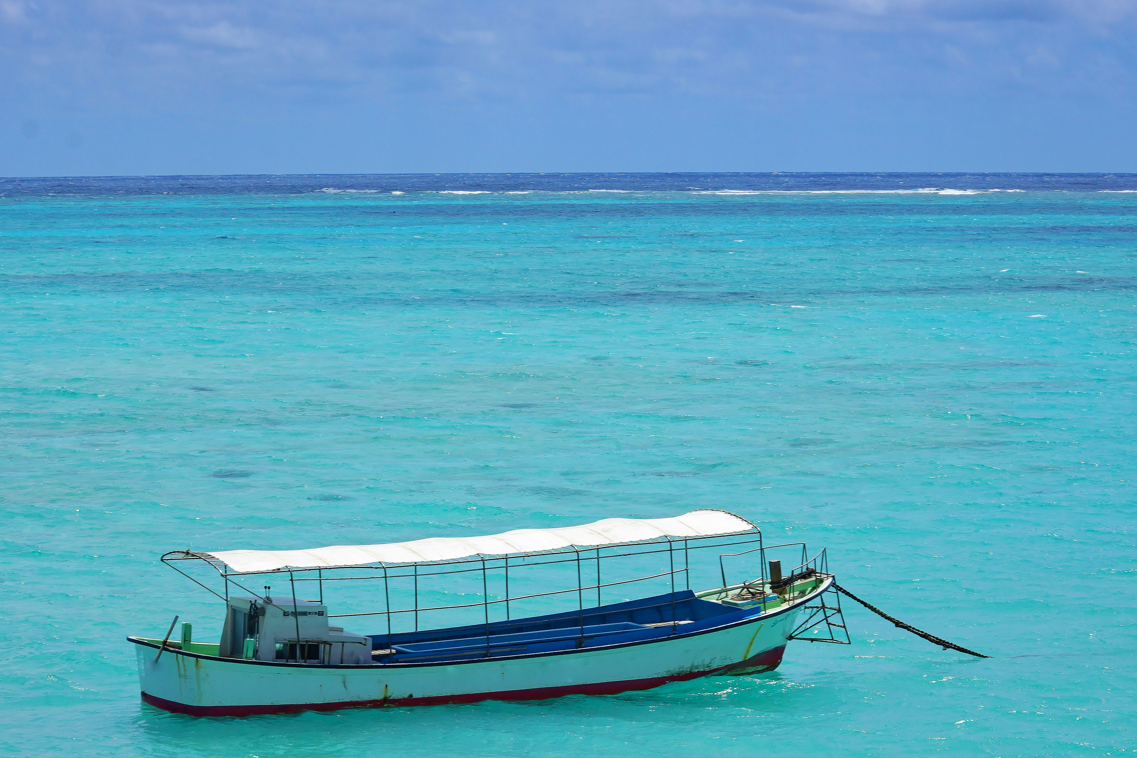 เรือสีขาวลอยอยู่ในมหาสมุทรสีน้ำเงิน