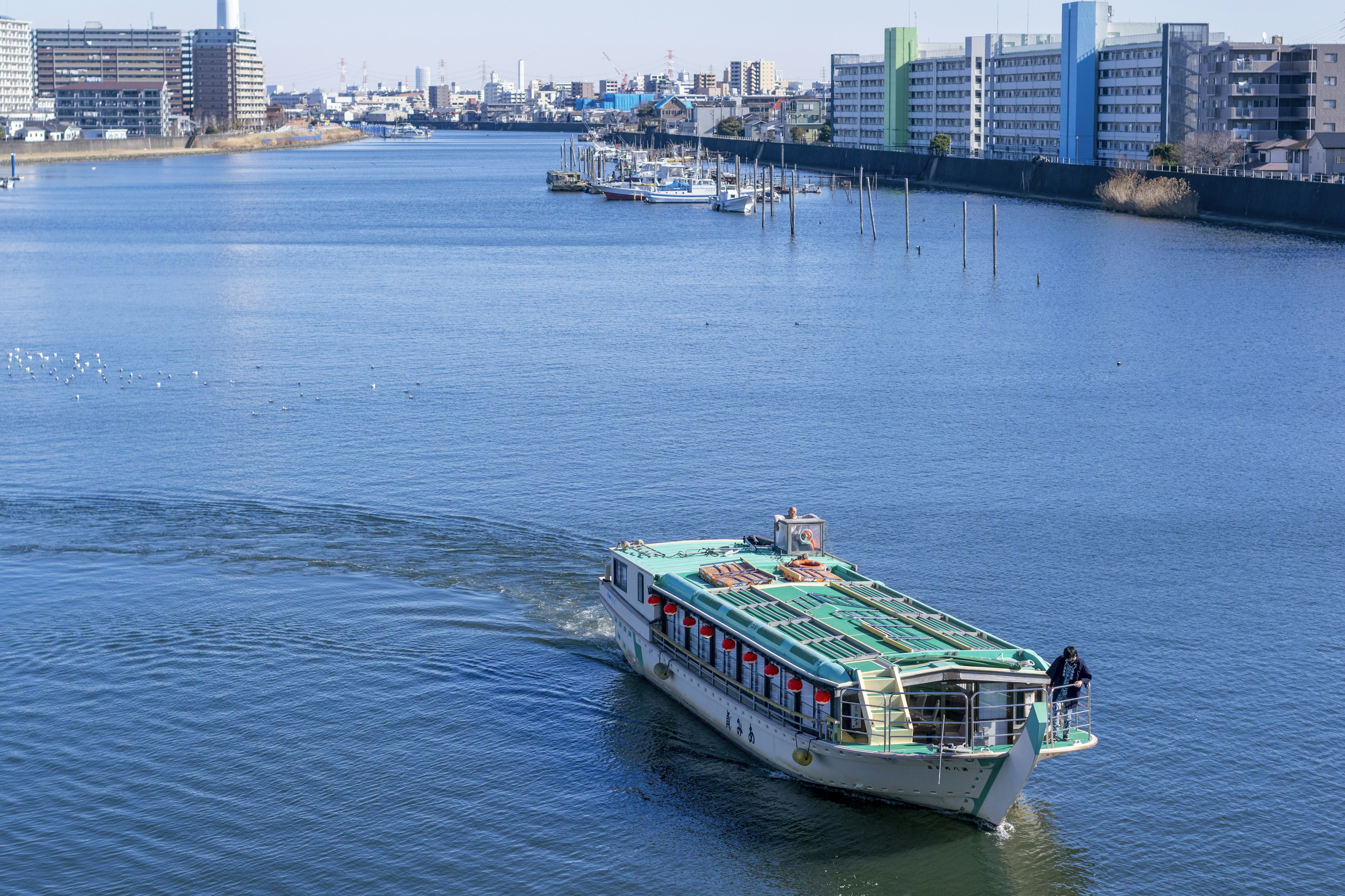 A water bus gliding across a calm water surface