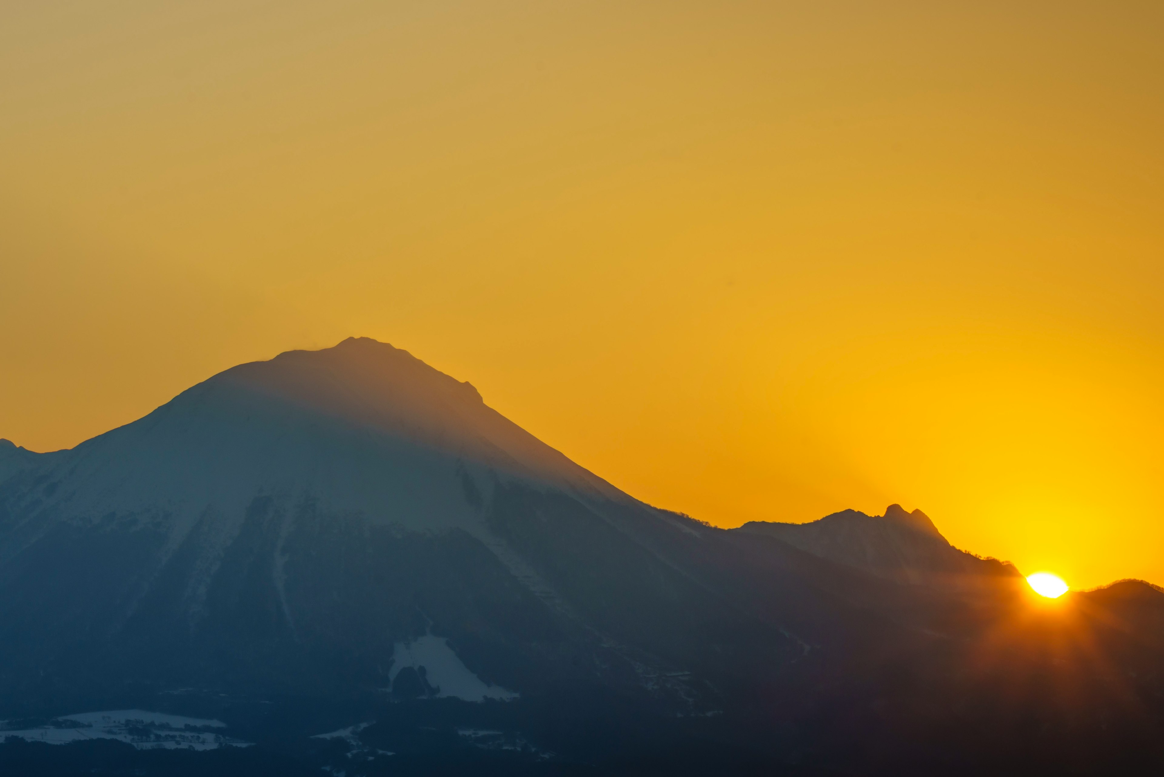 Wunderschöne Landschaft mit Sonnenuntergang hinter dem Berg