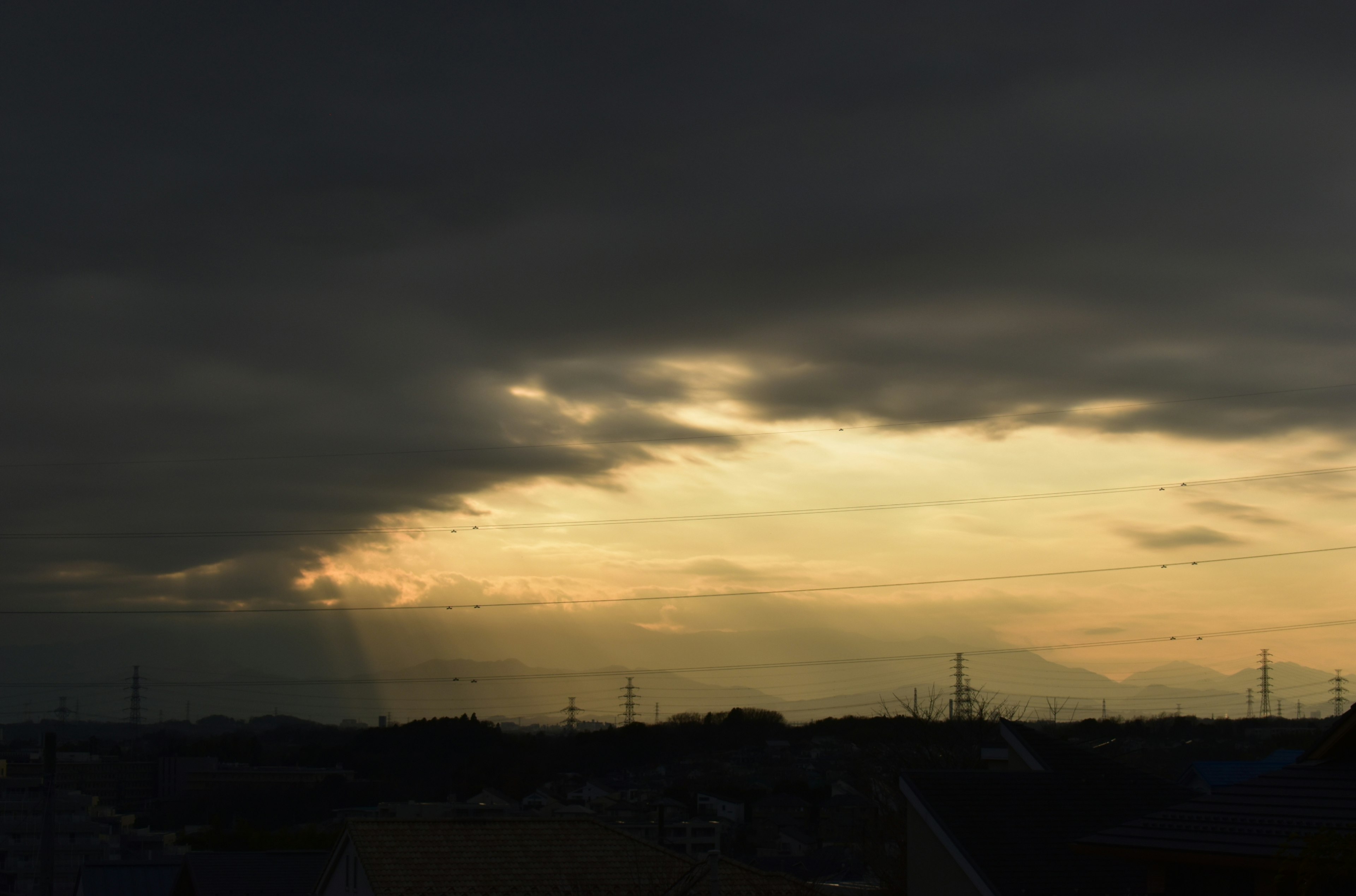 陰雲密布的天空和背景中的日落光輝