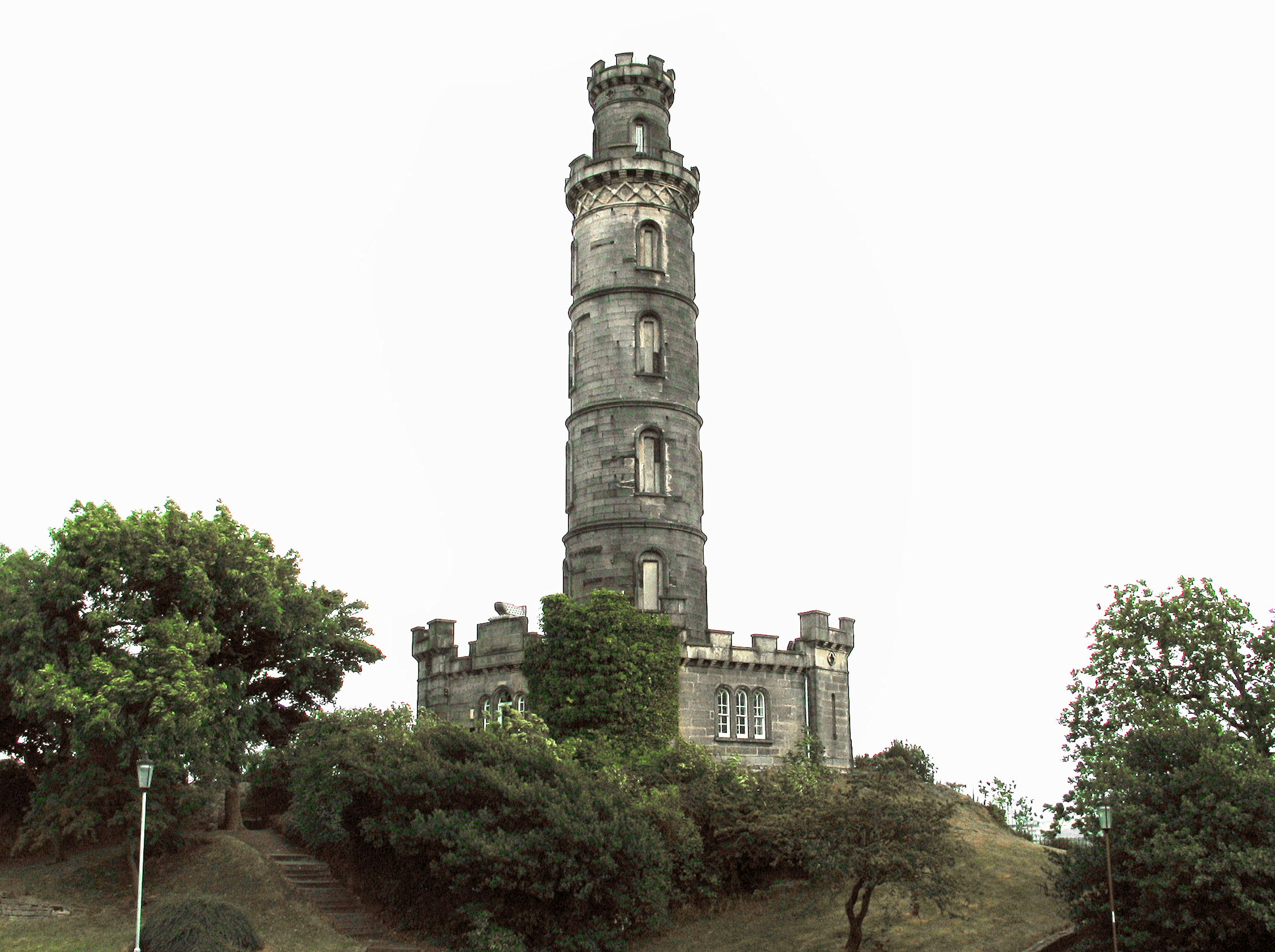 Hoher Steinturm umgeben von Grün und Hügeln